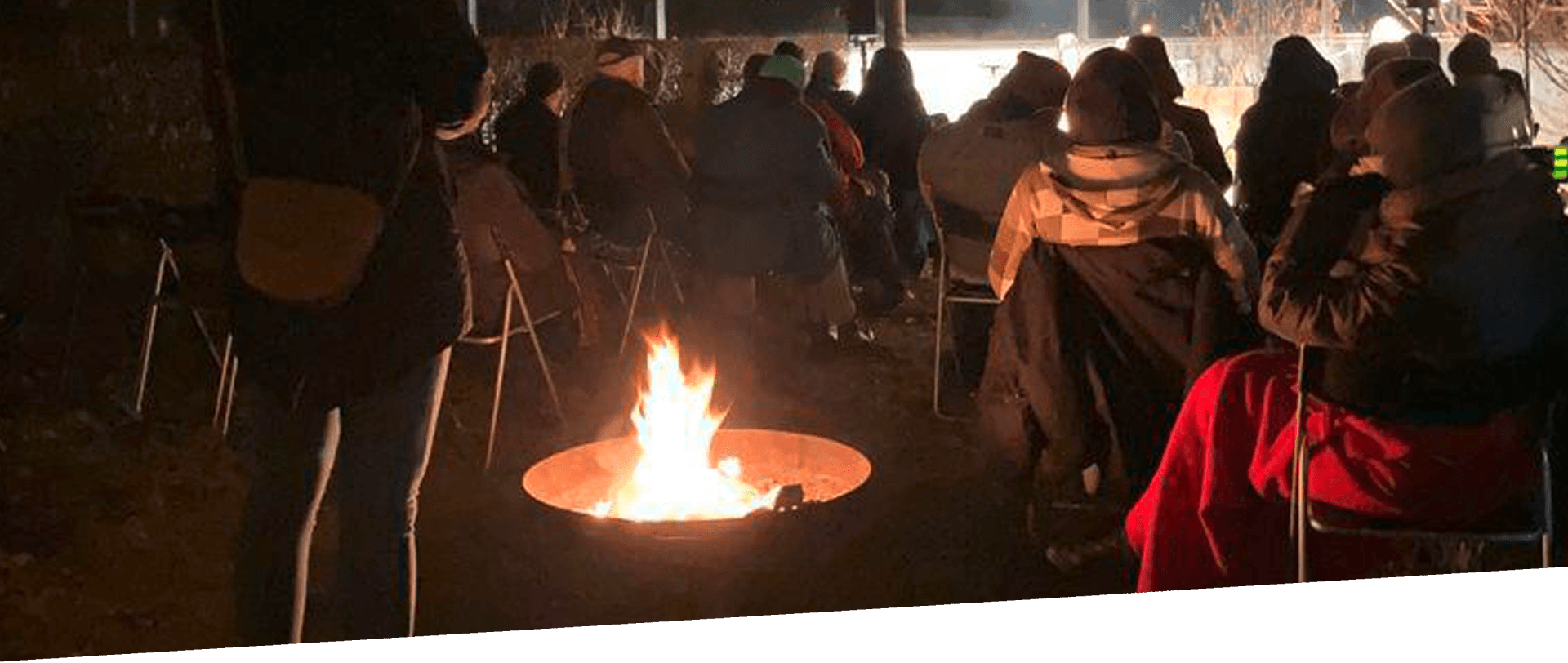 Menschen sitzen an einem Feuer auf der Straße