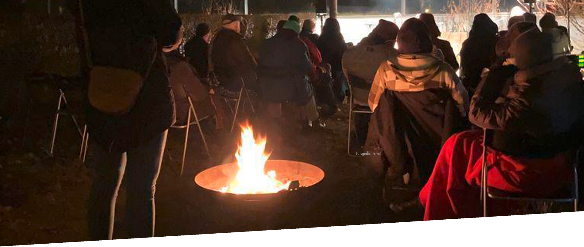 Menschen sitzen an einem Feuer auf der Straße