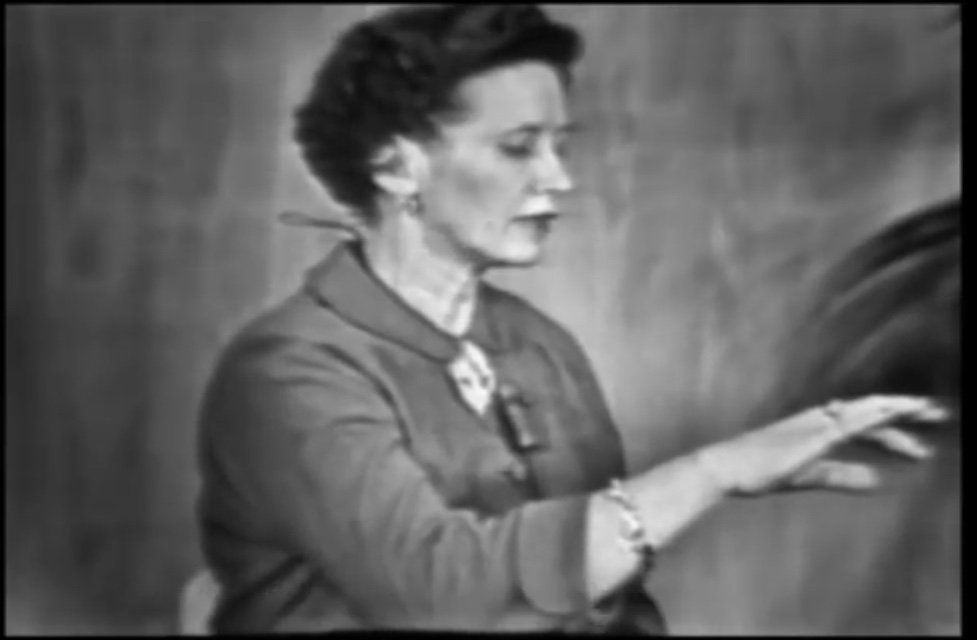 Betty Moore Erickson in Schwarz/Weiß hebt in Selbsthypnose Ihren rechten Arm leicht an