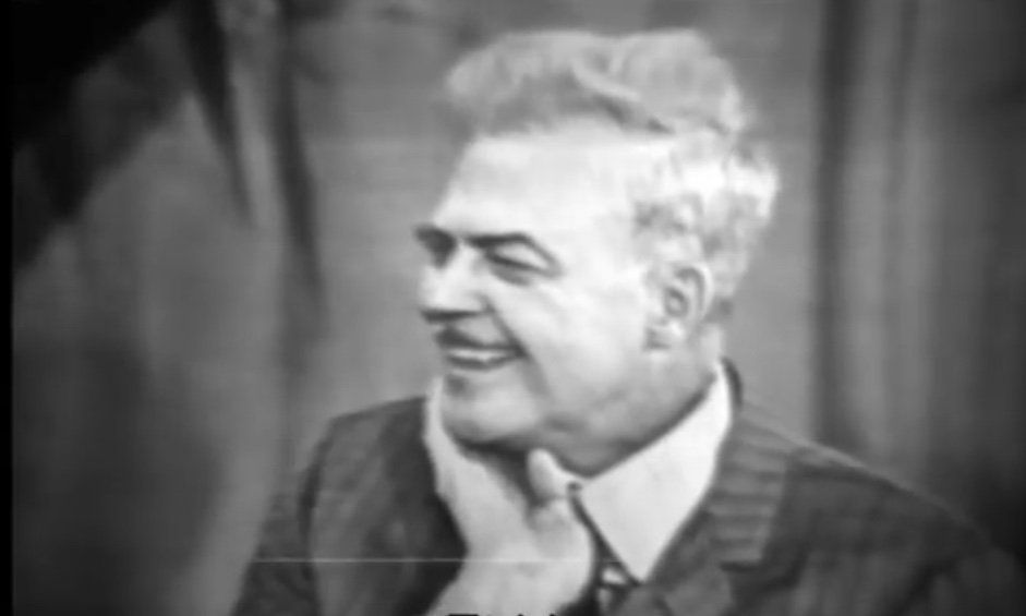 Portraitaufnahme vom lachenden Milton Erickson in Schwarz/Weiß. Screenshot von YouTube