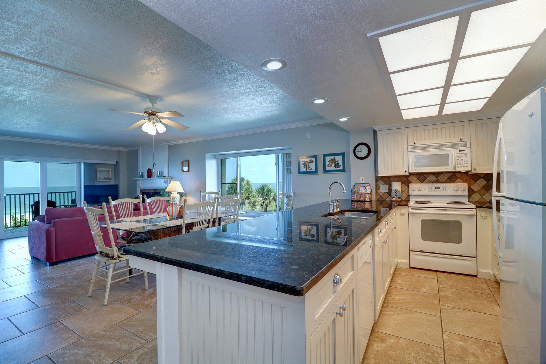 Kitchen with white cabinets, black granite counter,range , fridge beige tile floor