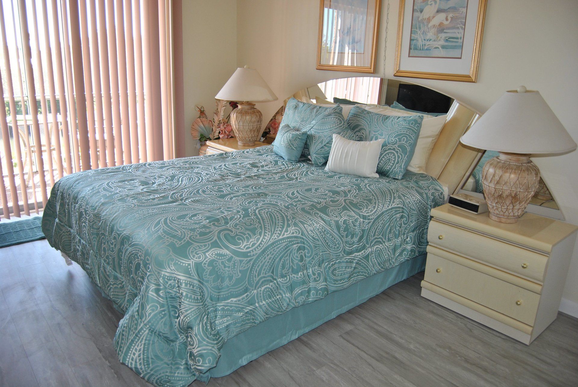 Queen bed with blue cover and 2 side tables