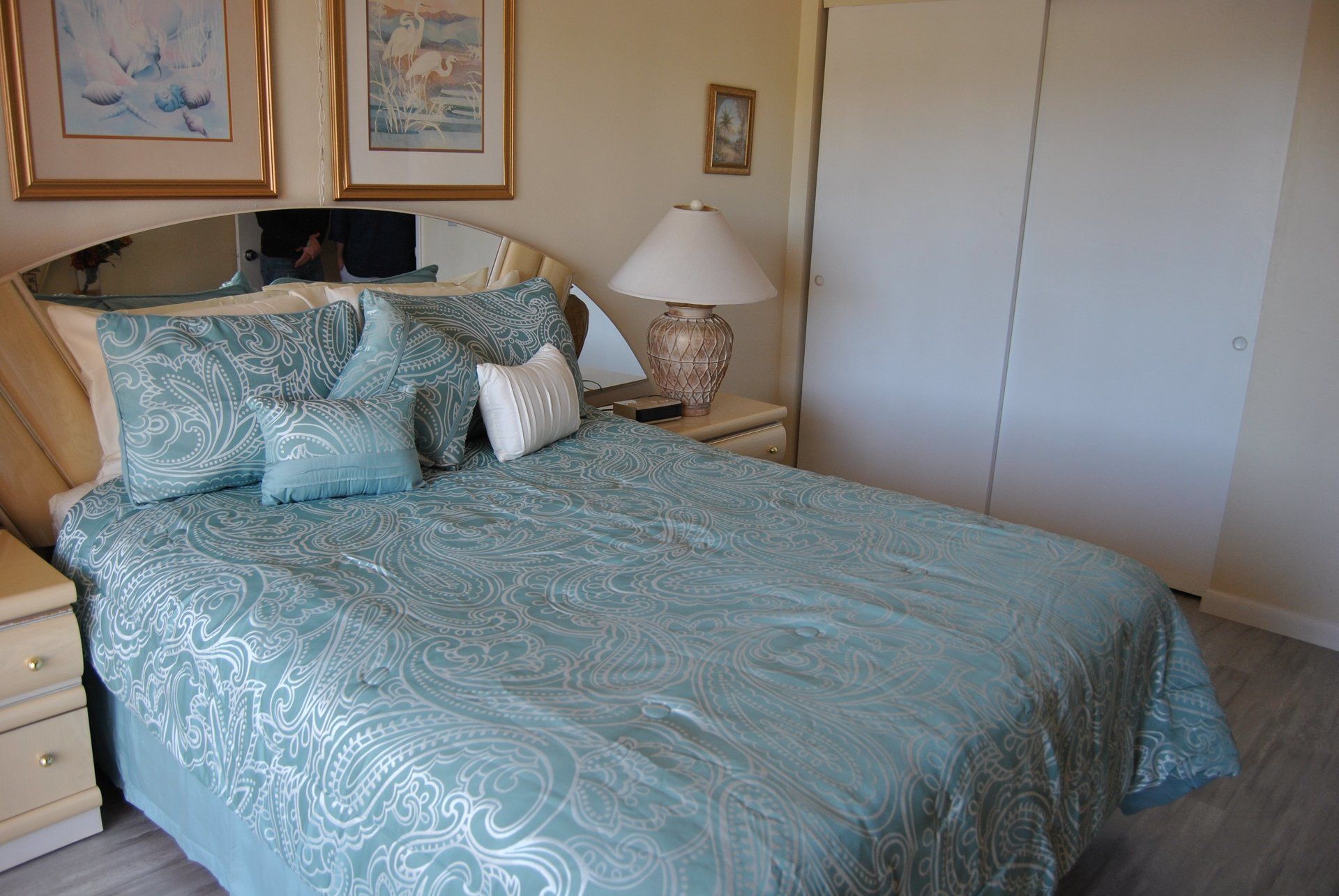 Queen bed with blue cover and 2 side tables