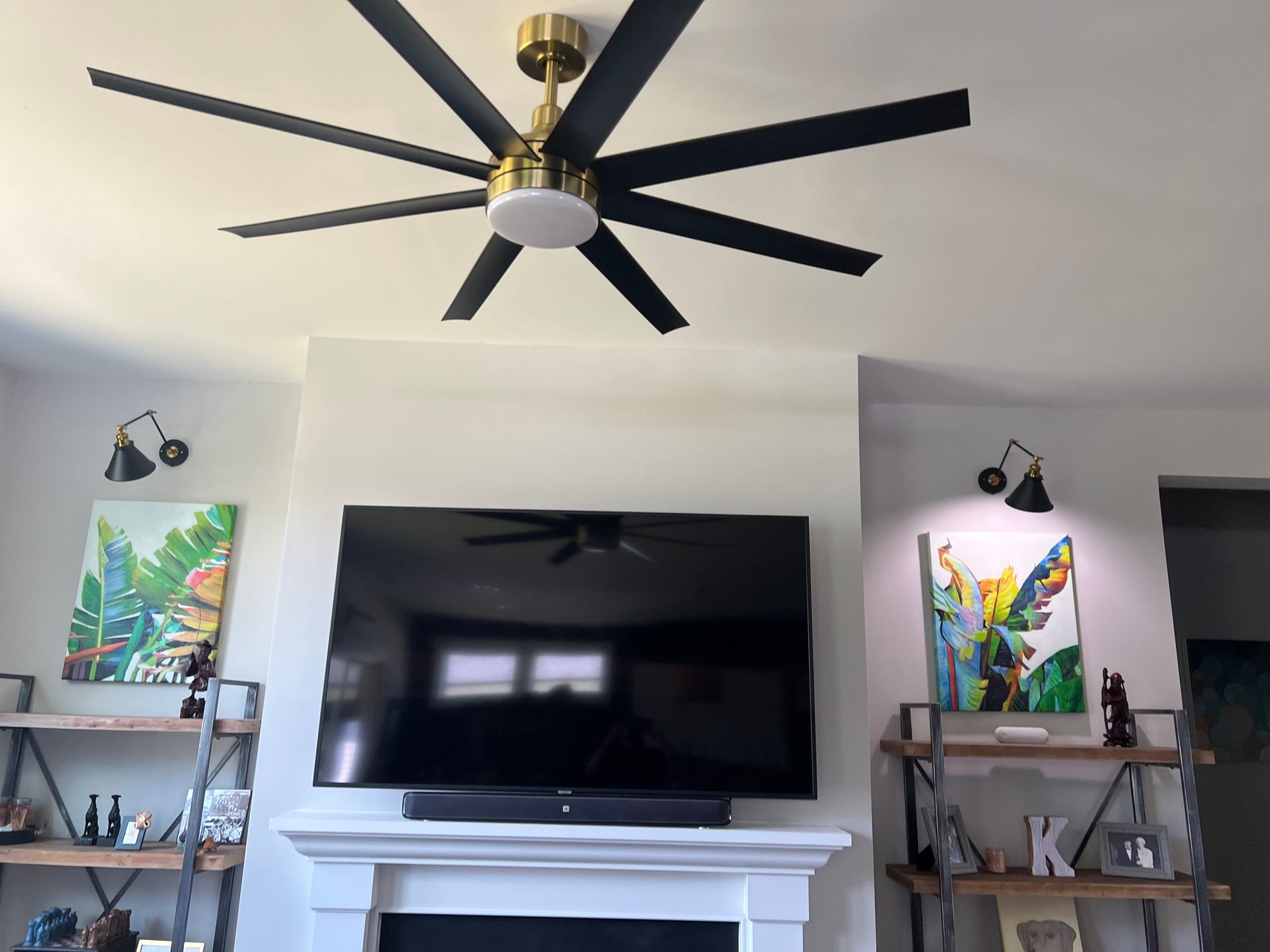 Living room ceiling fan and TV wall mount installation above fireplace mantel with nearby wall sconces – Wake Forest, NC.