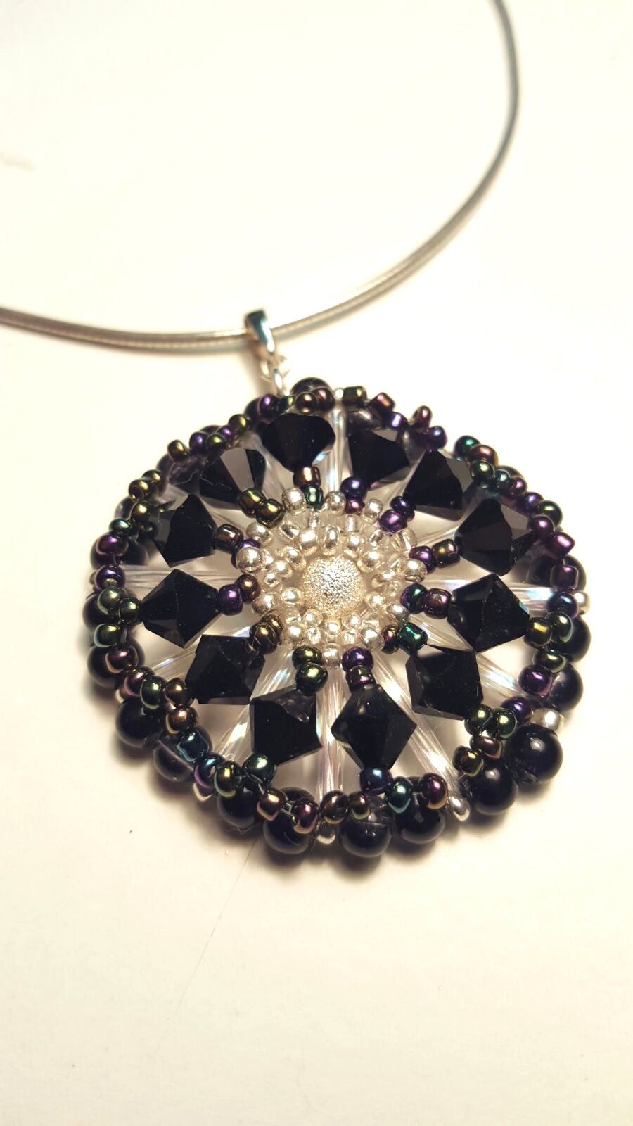Woven pendant consisting of black diamond swarovski bicone crystal beads and various shades of seed beads. Pendant displayed with sterling silver collar not included in the price.