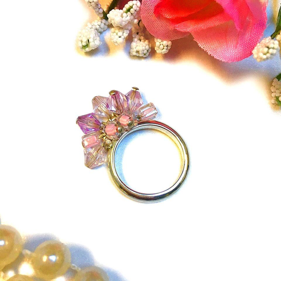 Sterling silver charm ring adorned with various chades of pink beads.