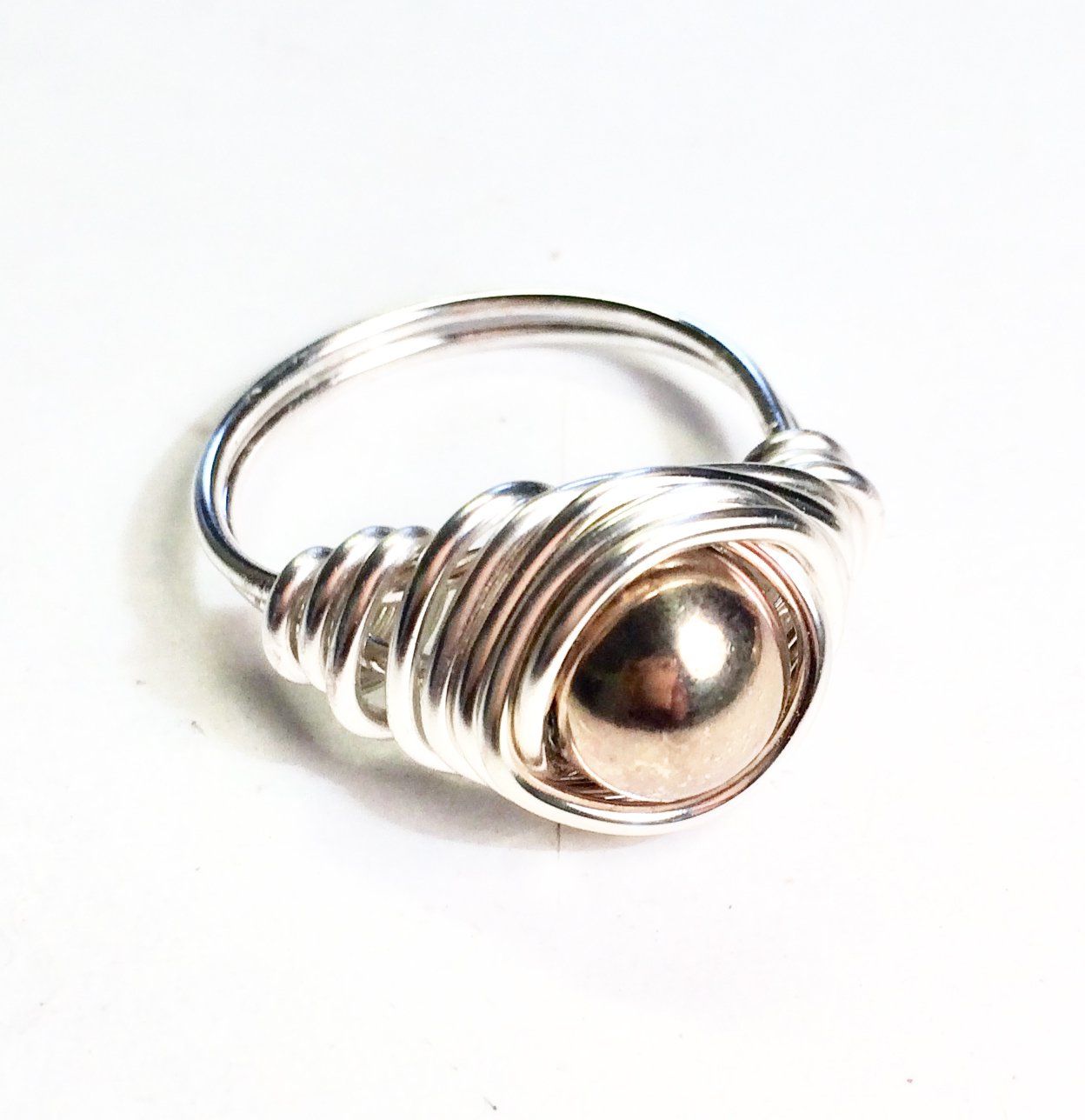Copper, silver or gold plated wire wrapped and shaped around various types of beads to create a stunning ring.