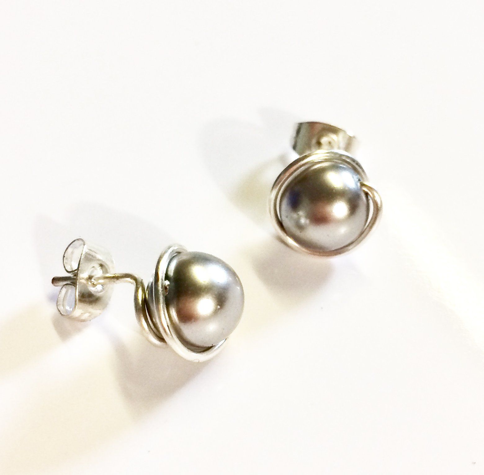 Various coloured swarovski glass pearls wrapped in plated wire to form a stud earring.
