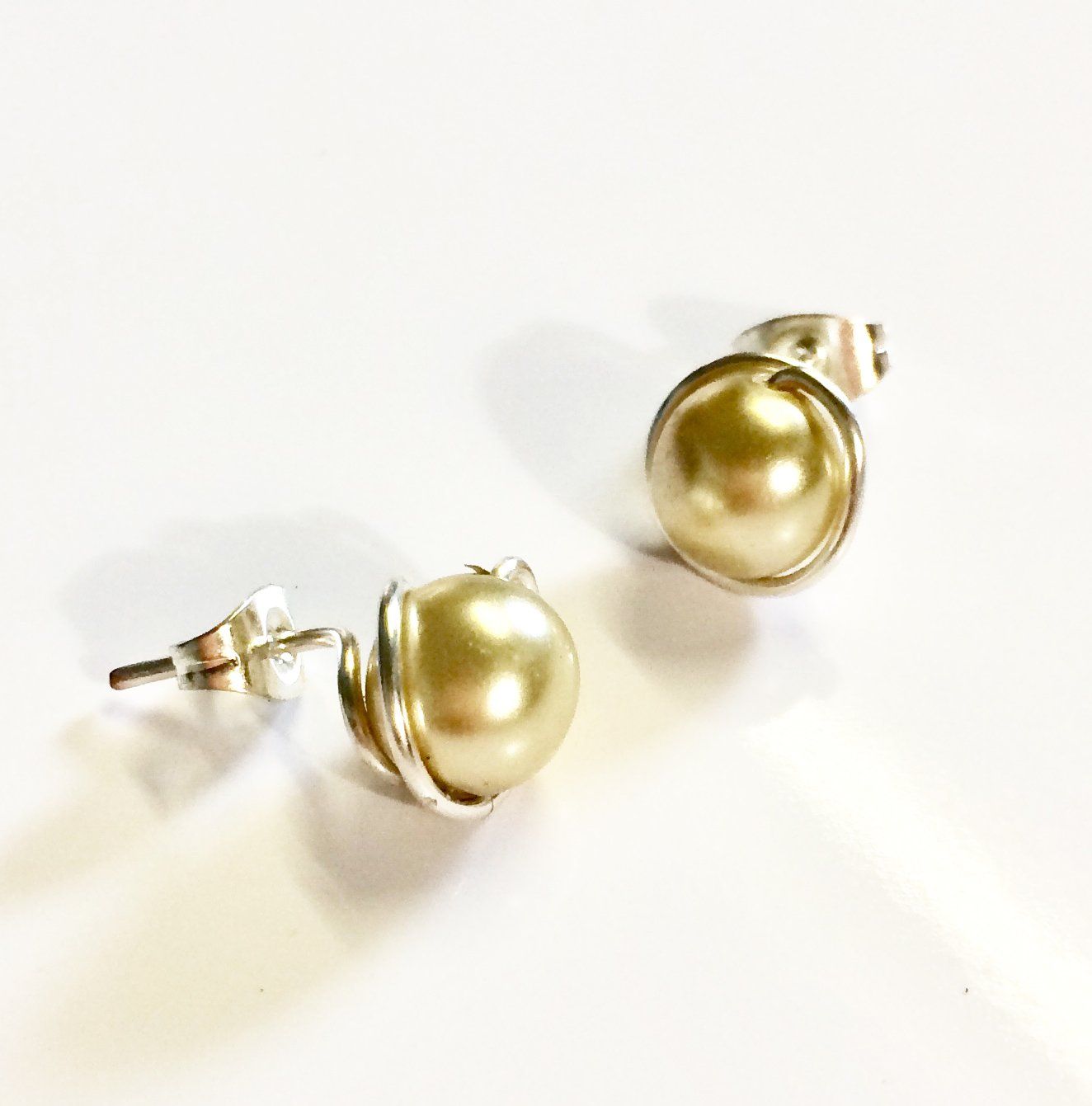 Various coloured swarovski glass pearls wrapped in plated wire to form a stud earring.