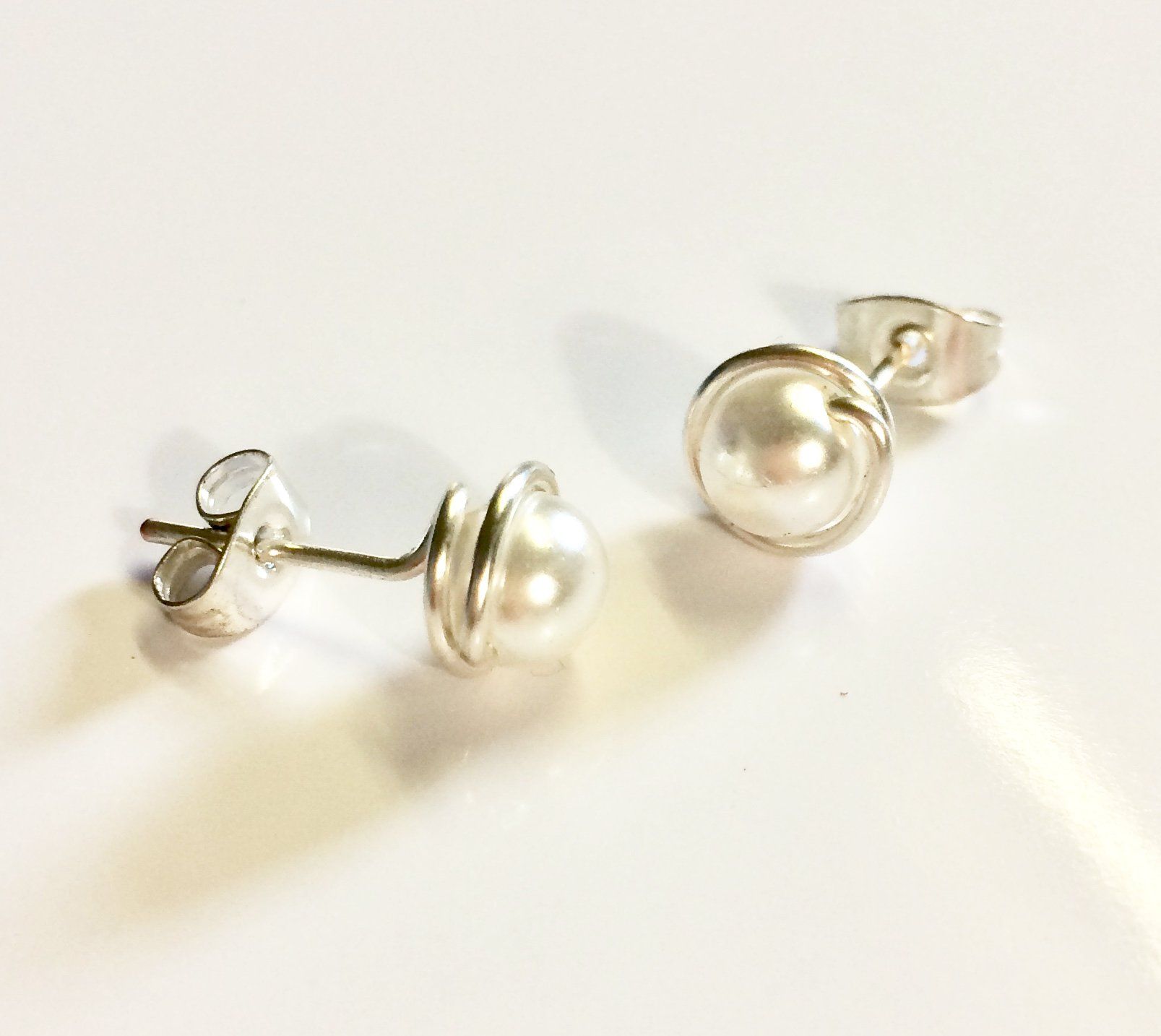 Various coloured swarovski glass pearls wrapped in plated wire to form a stud earring.