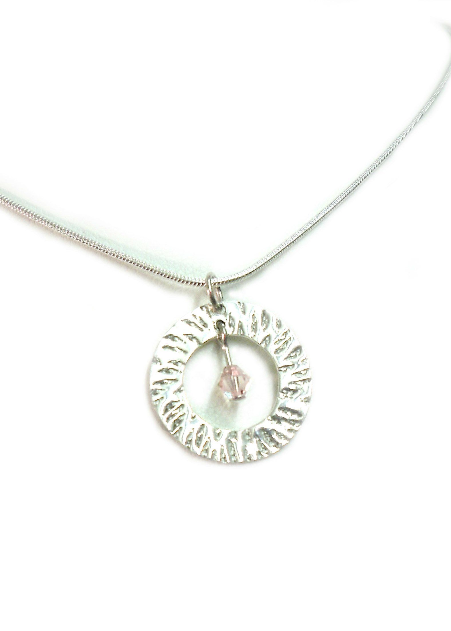 Sterling silver textured open circle pendant with 'silk' swarovski crystal bead.