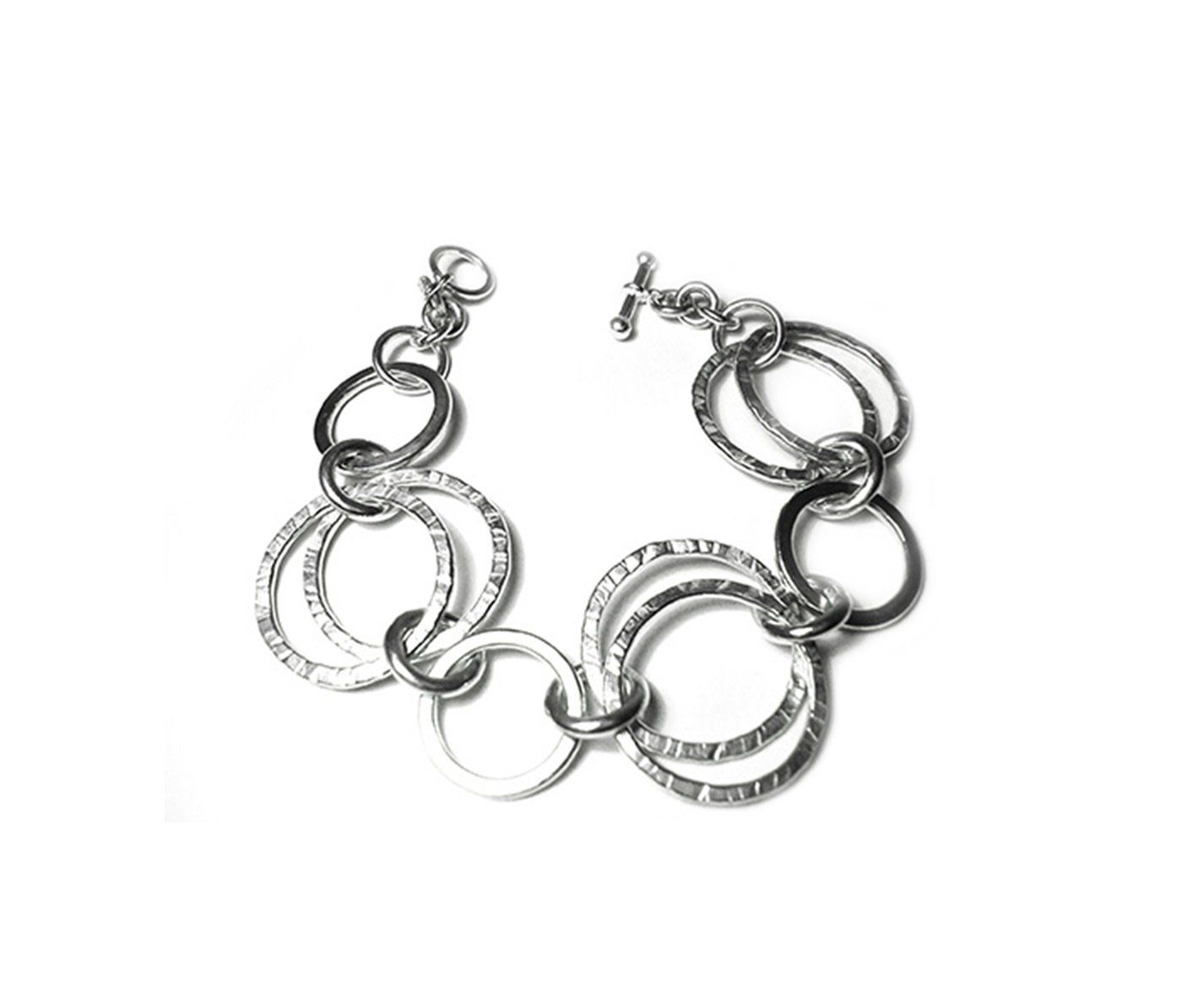 Heavy sterling silver circle style bracelet with hammered flat circles & rings.