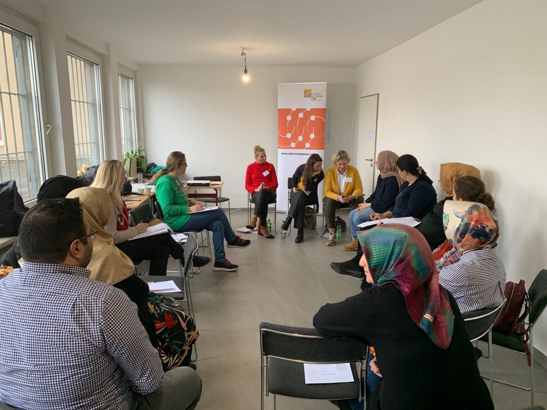 Eltern mit Einwanderungsgeschichte im Gespräch. Link führt zu Projektseite Elterngespräche