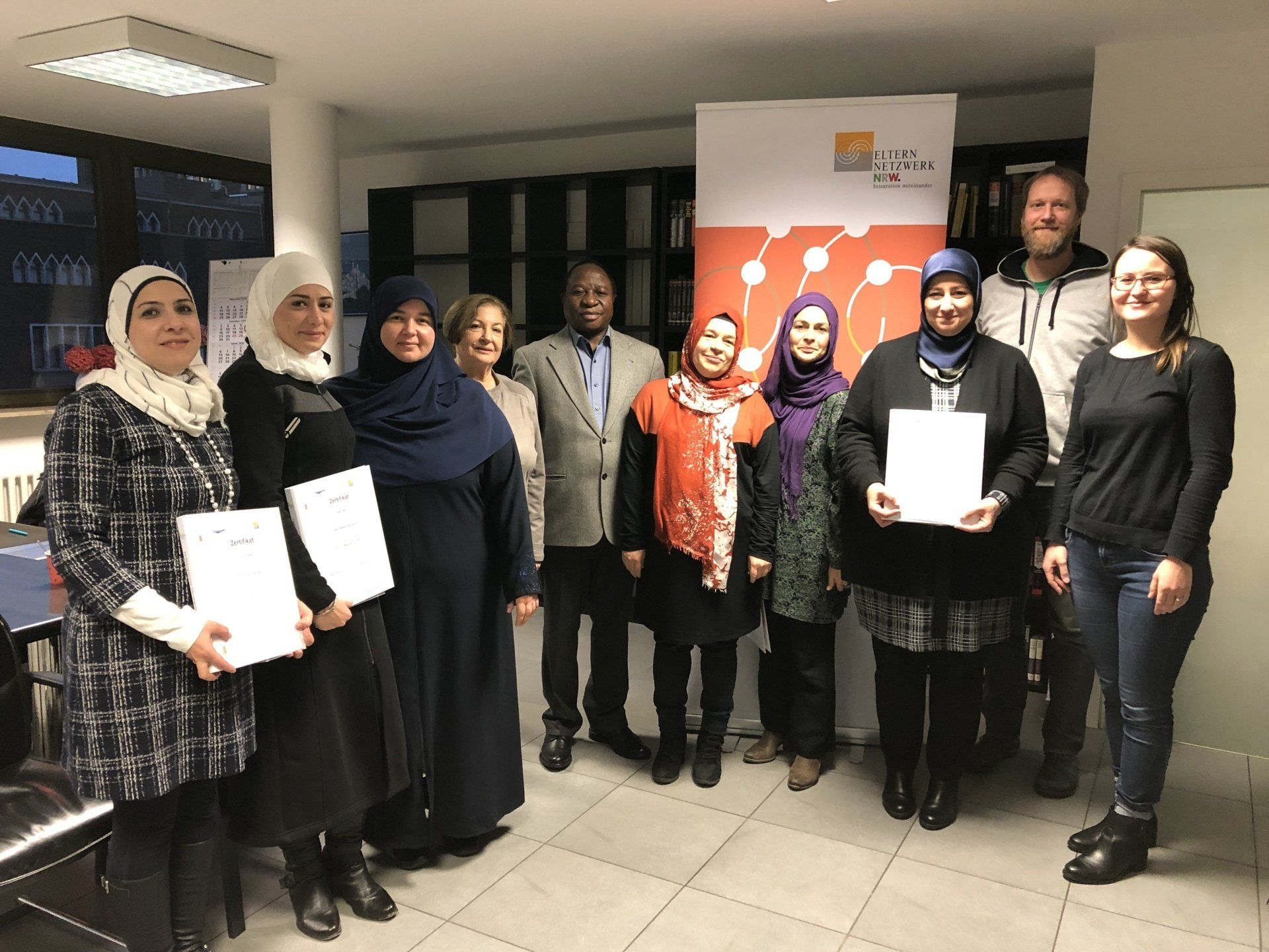 Gruppenfoto von zwei Männern und mehrerer Frauen, die stolz ihre Zertifikate in der Hand halten