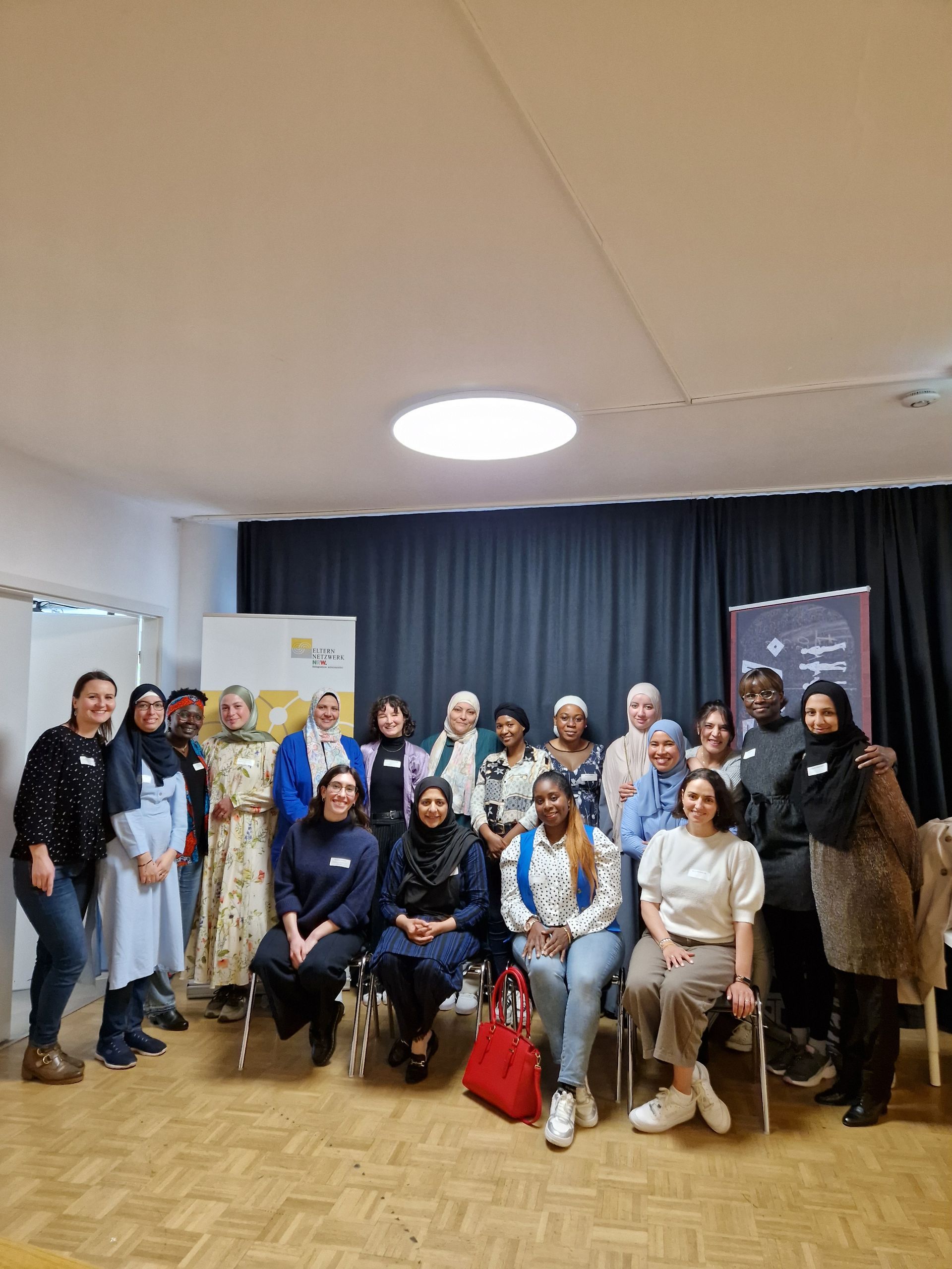 Großes Gruppenbild vor schwarzem Vorhang von den Teilnehmerinnen der Auftaktveranstaltung von Her Diversity