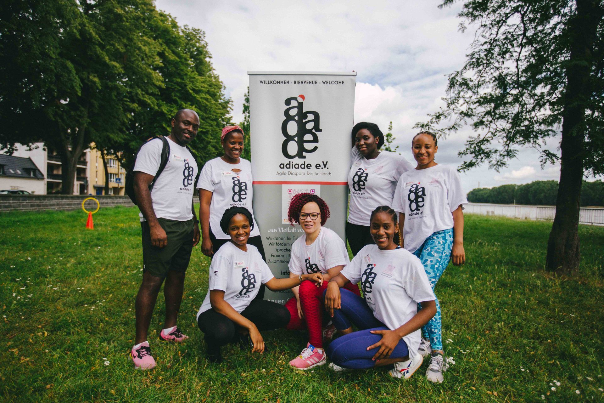 Mitglieder unseres Mitgliedvereins adiade e.V. vor einem Banner im grünen Park