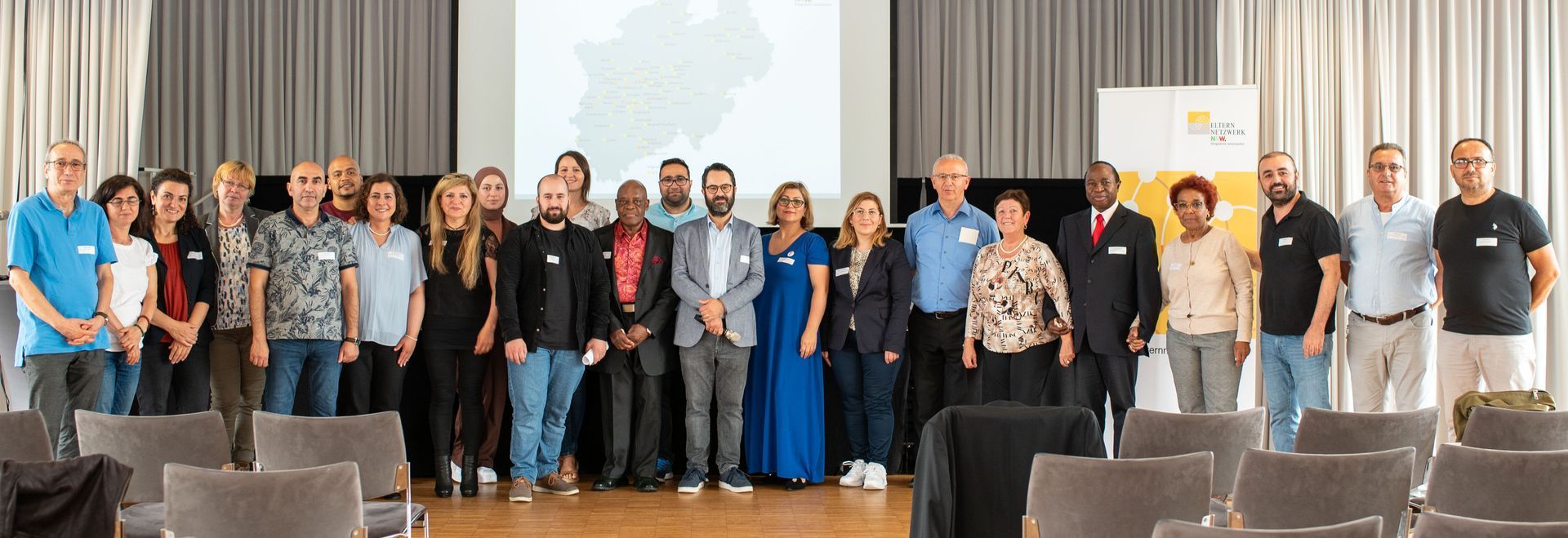 Großes Gruppenbild der Mitgliederversammlung in Düsseldorf. Auf der Leinwand die Vereinslandkarte.