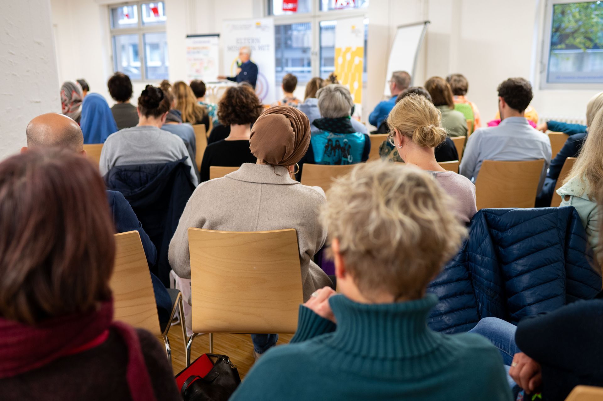 Blick von hinten in das Publikum mit interessierten Teilnehmern und Teilnehmerinnen an der Fachveranstaltung
