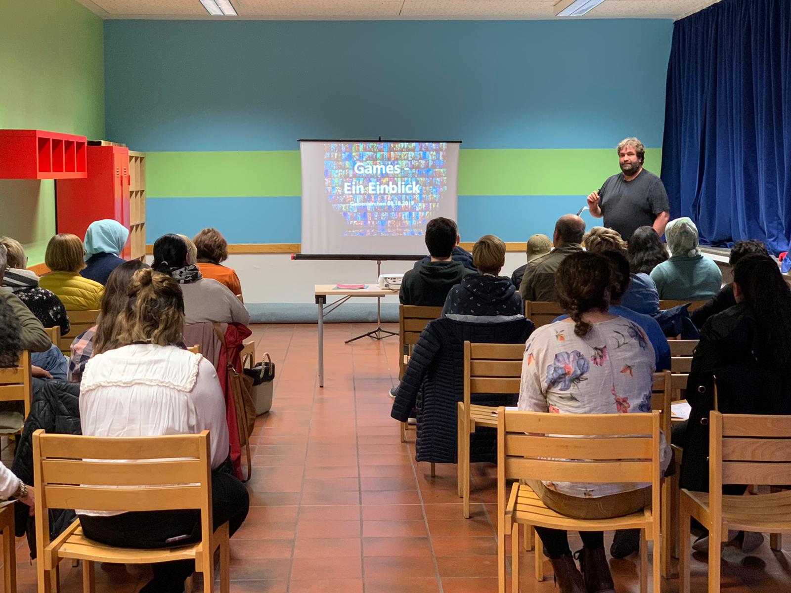 Workshop Nutzung von Medien in Gelsenkirchen, Elterngespräche-Teilnehmer*innen sitzen im Publikum zum Referenten gerichtet.