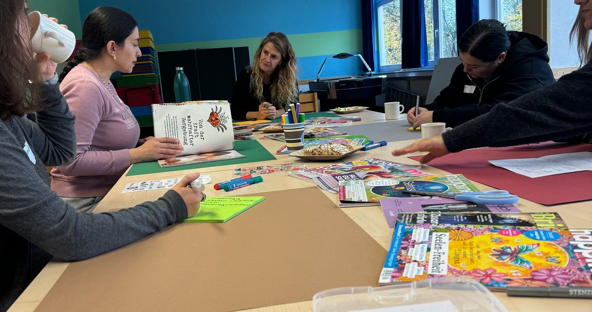 Vision-Board-Workshop im Projekt SelF - Selbstbehauptung für Frauen. Frauen sitzen am Tisch und werden kreativ