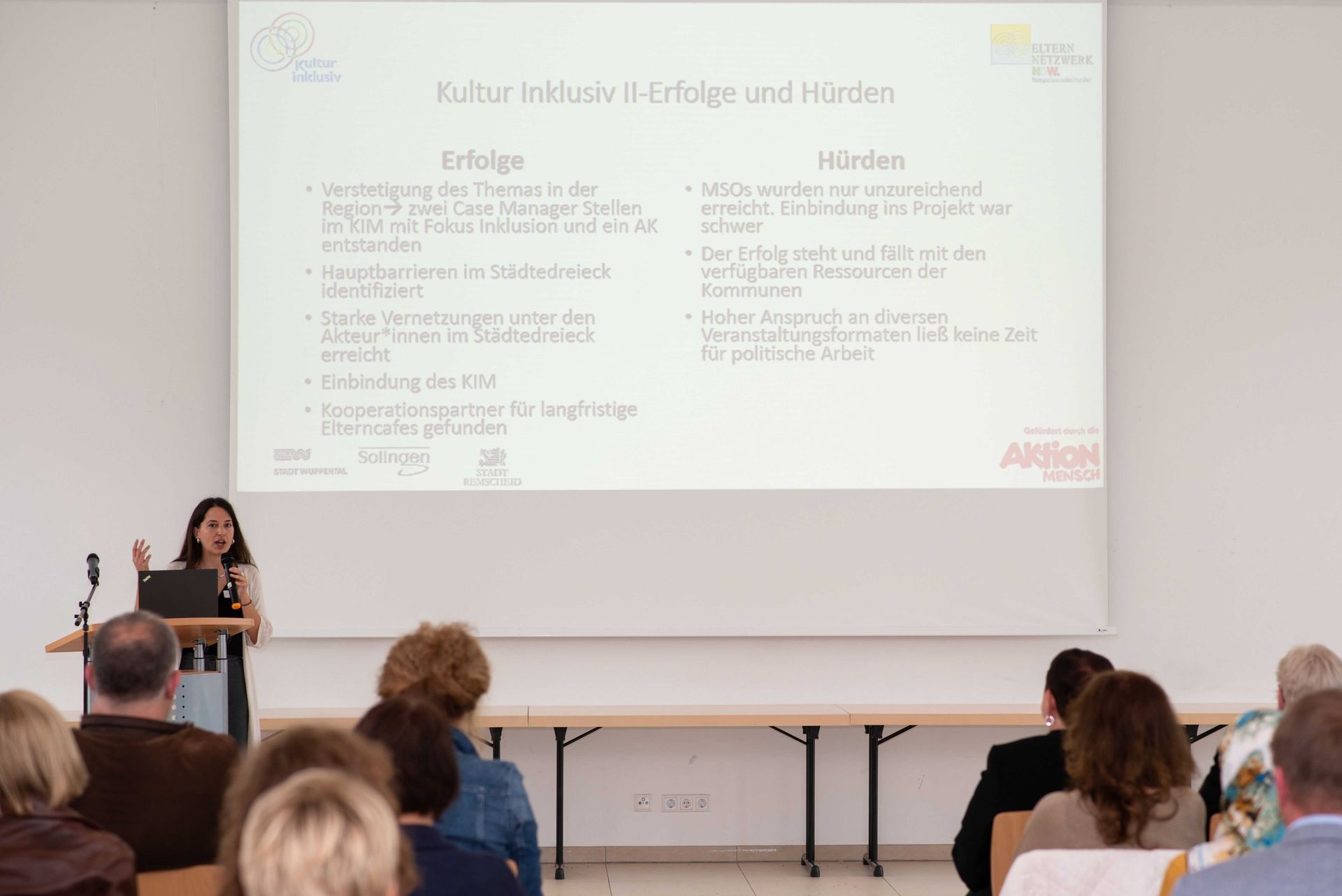 Jassin Fetahovic, Projektleiterin von Kultur Inklusiv berichtet am Rednerpult über die Erfolge und Hürden im Projekt.
