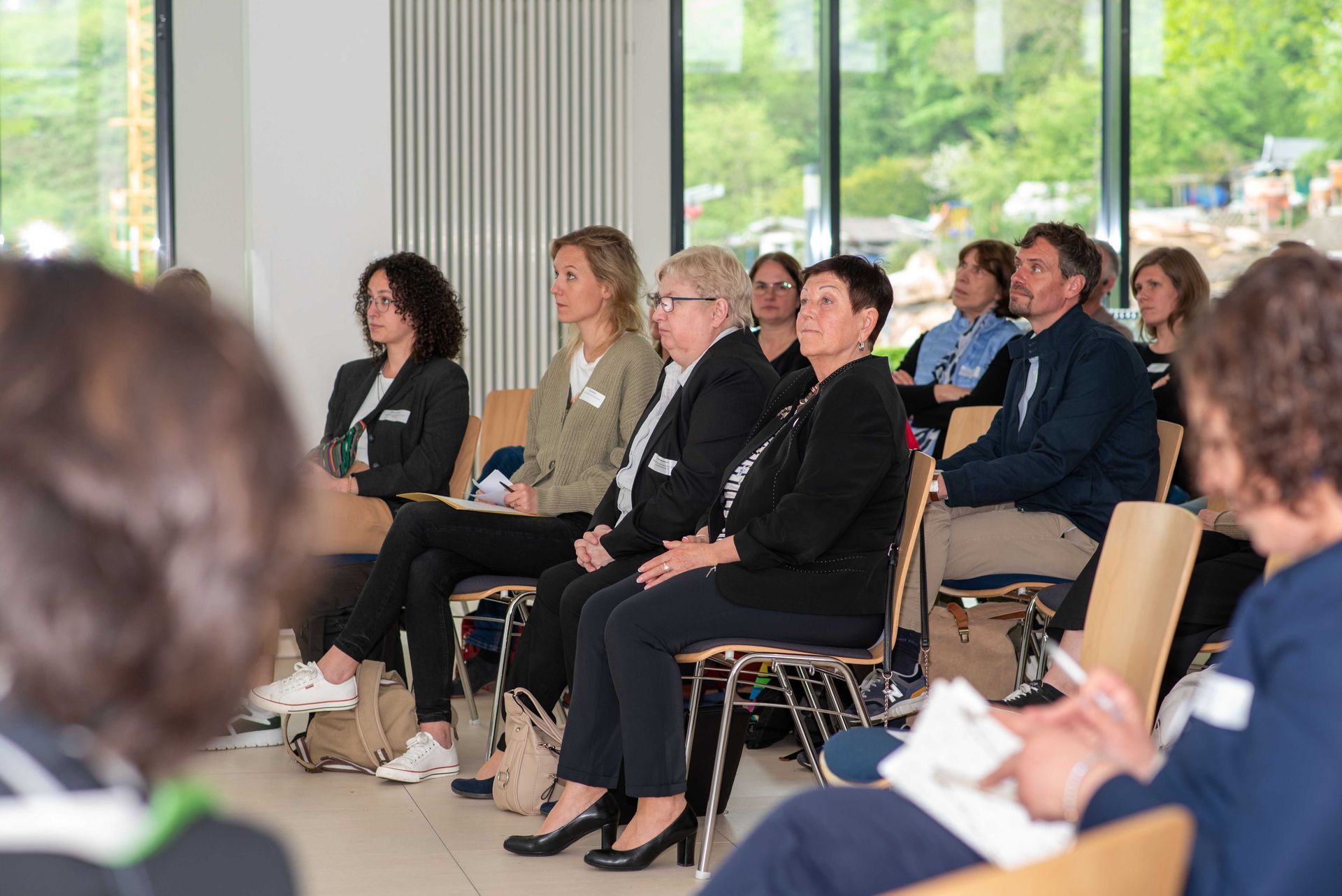 Das Publikum bei der Zukunftskonferenz im Projekt Inklusiv. Draußen ist es grün.