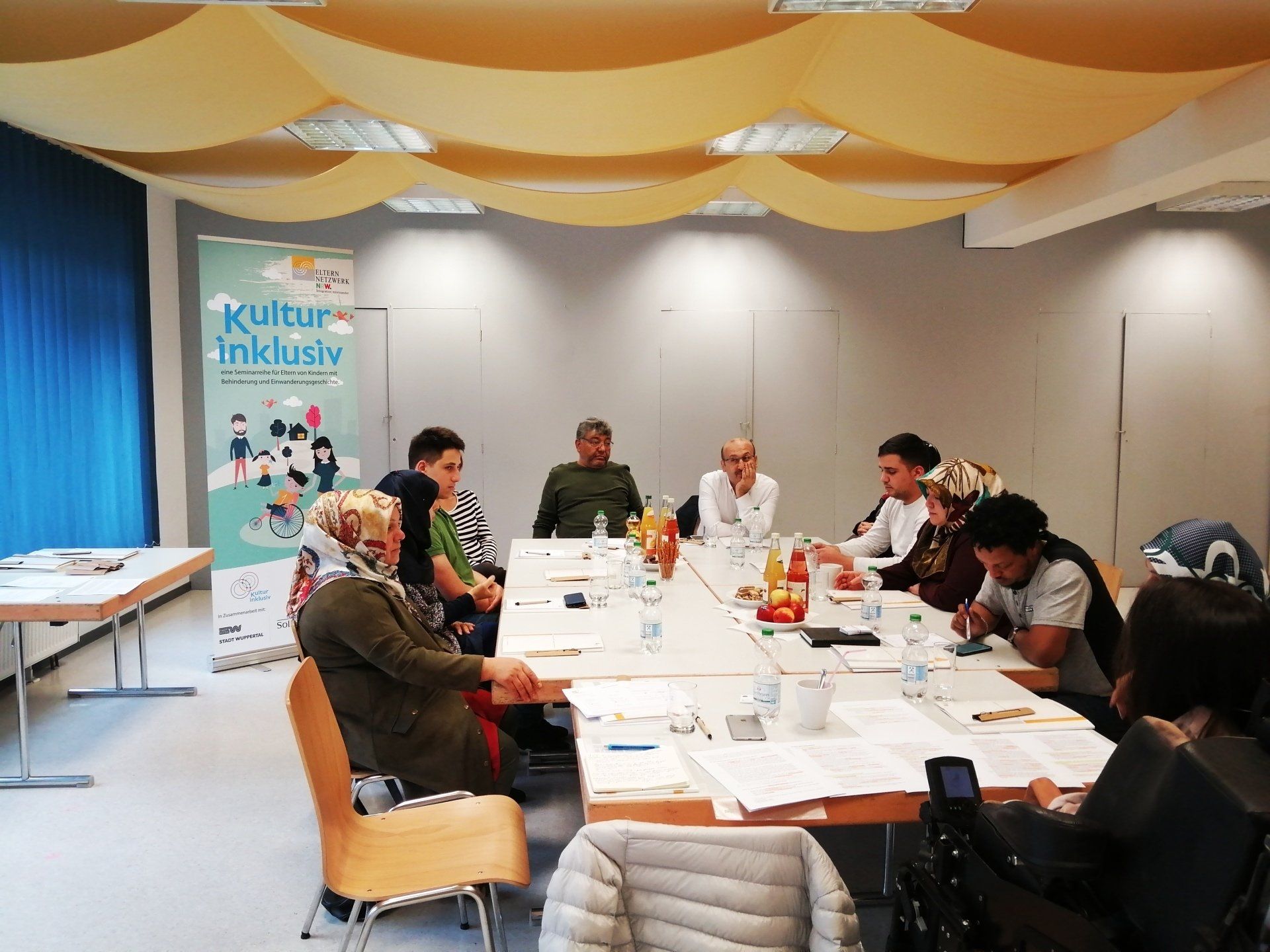 Eltern um einen großen Tisch bei der Veranstaltung für Eltern zum Thema