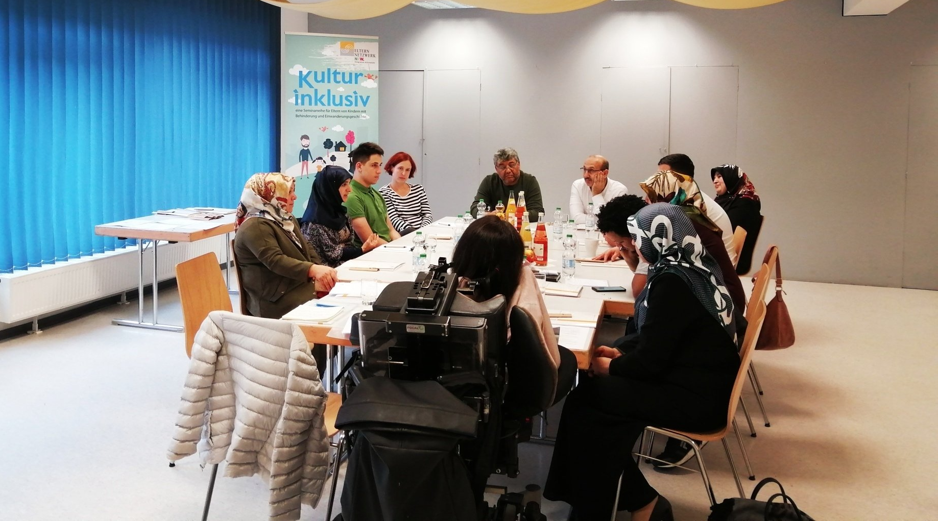Eltern um einen großen Tisch bei der Veranstaltung für Eltern zum Thema