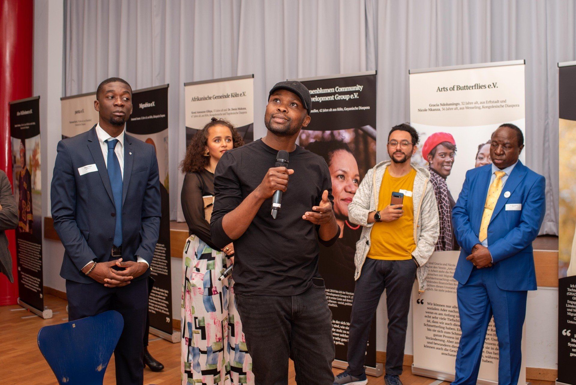 Bei der Ausstellungseröffnung von meeting Diaspora, die Gäste stehen in der Ausstellung. Link führt zu Projektseite meeting Disapora