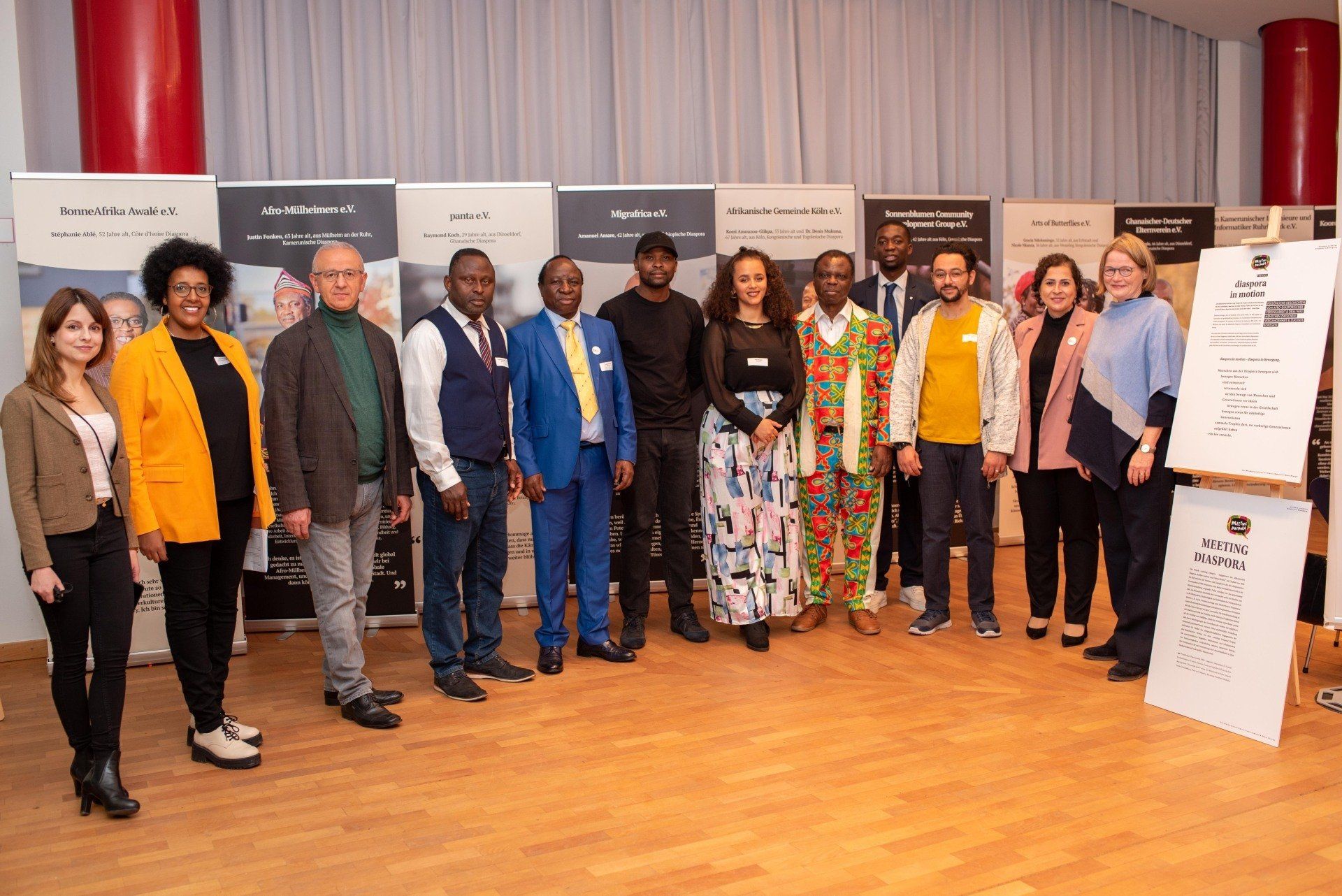 Gruppenbild in der neu eröffneten Ausstellung von Diaspora in Motion, darunter die Kuratorin Shavu Nsenga und Francis Oghuma.
