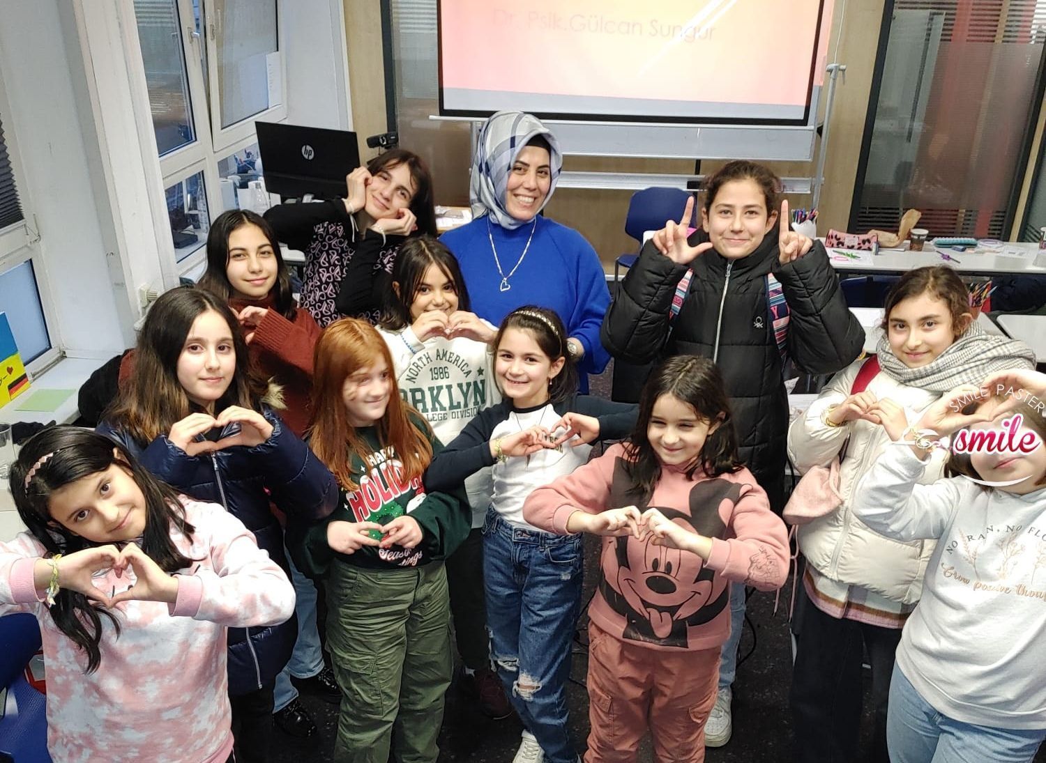 Mitglieder des Bergischen Bildungsbund. Gruppenbild von Kindern, die Herzen mit Händen formen.