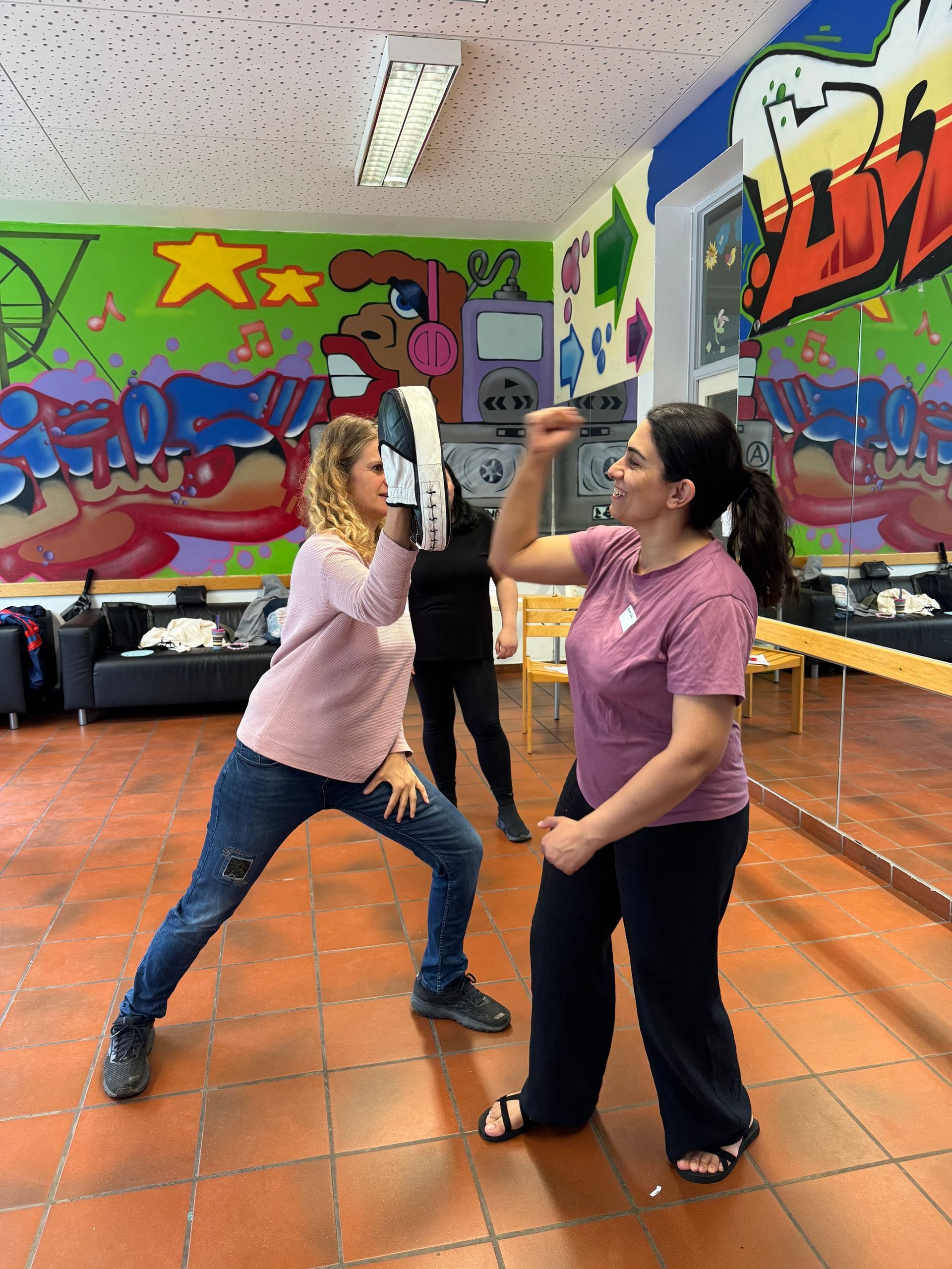 Frau schlägt auf Pratze, die Trainerin hält. WenDo-Kurs im Projekt SelF - Selbstbehauptung für Frauen