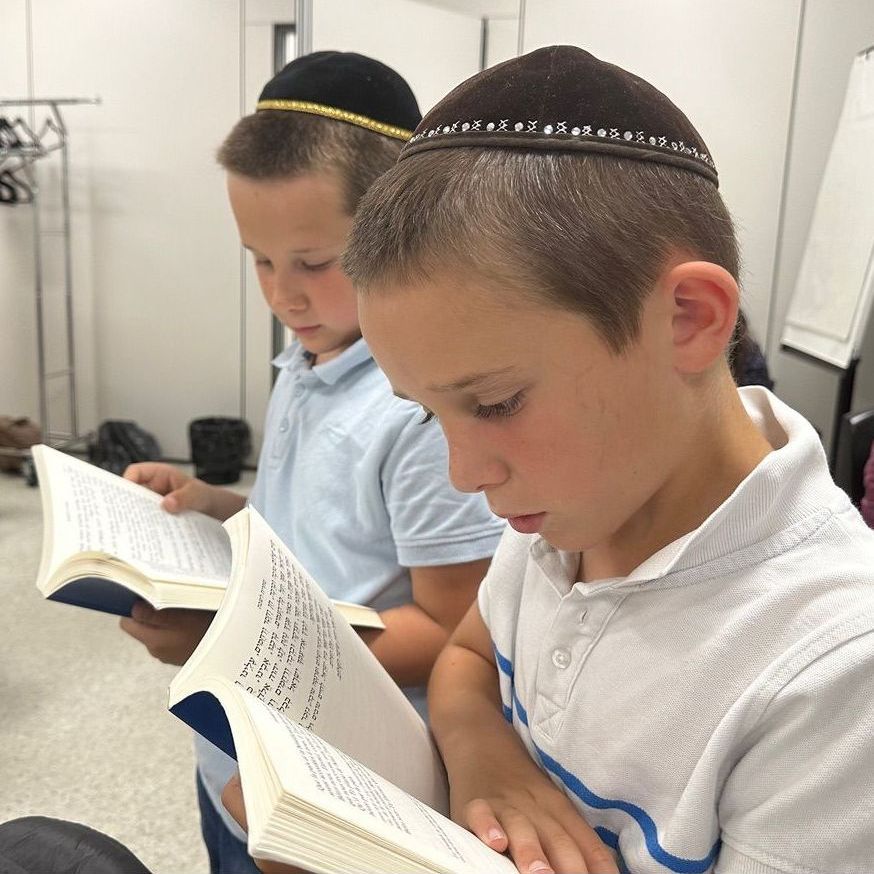 Deux enfants juif portant une kippa lisent le siddour.
