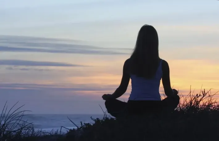 Meditierende Frau am Meer