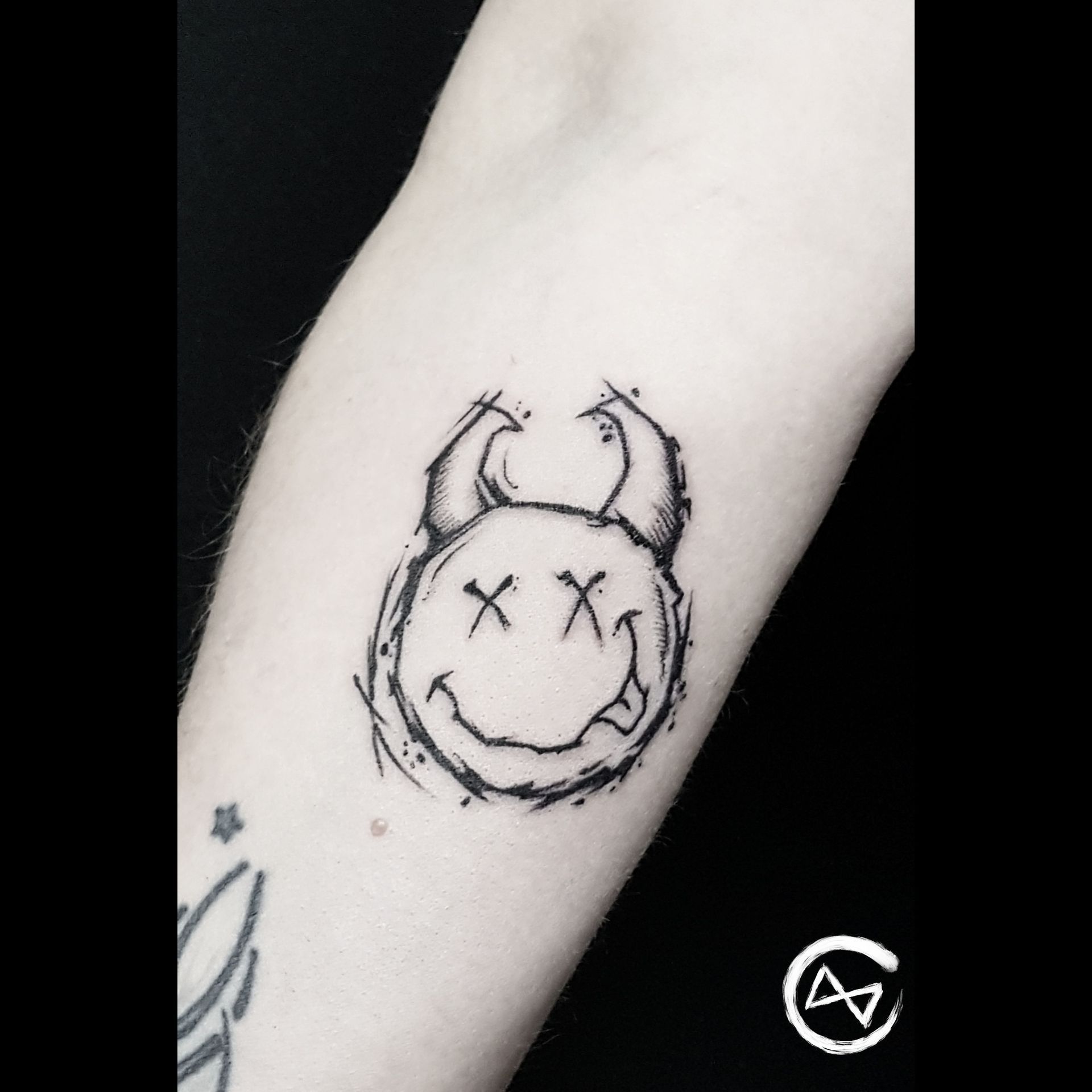 Ein sketchy tätowierter Smiley mit Teufelshörnern