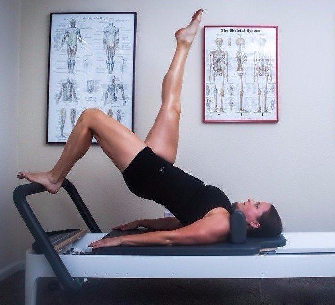 Flexible Pilates instructor demonstrating challenging Pilates balancing exercises on Allegro 2 reformer in Private Pilates studio Scottsdale, AZ