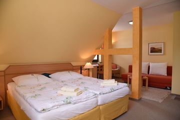 Warmes Zimmer mit Doppelbett und Zierquerbalken