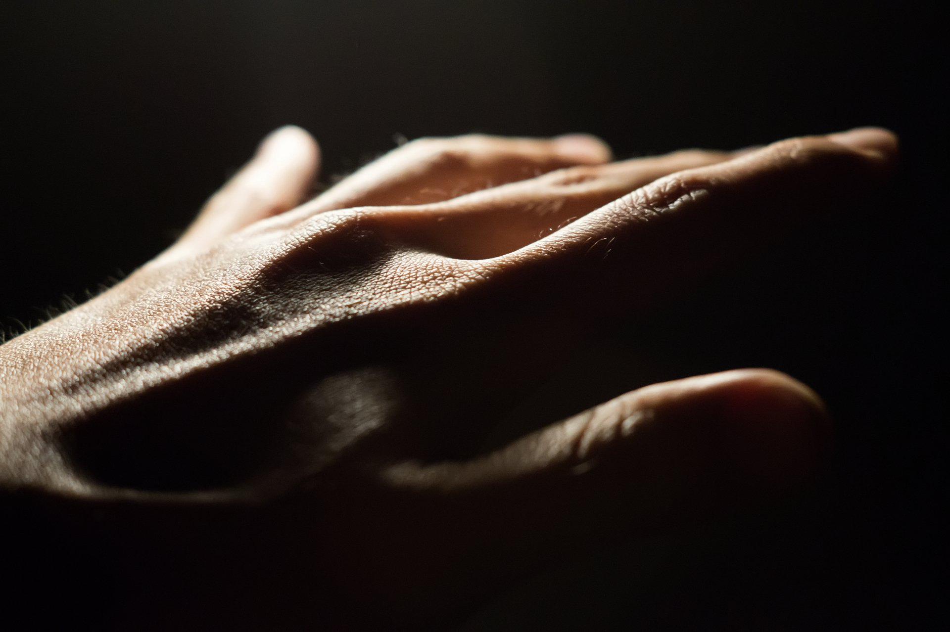 Hand eine Hand bewegt sich sinnlich aus dem Dunkel