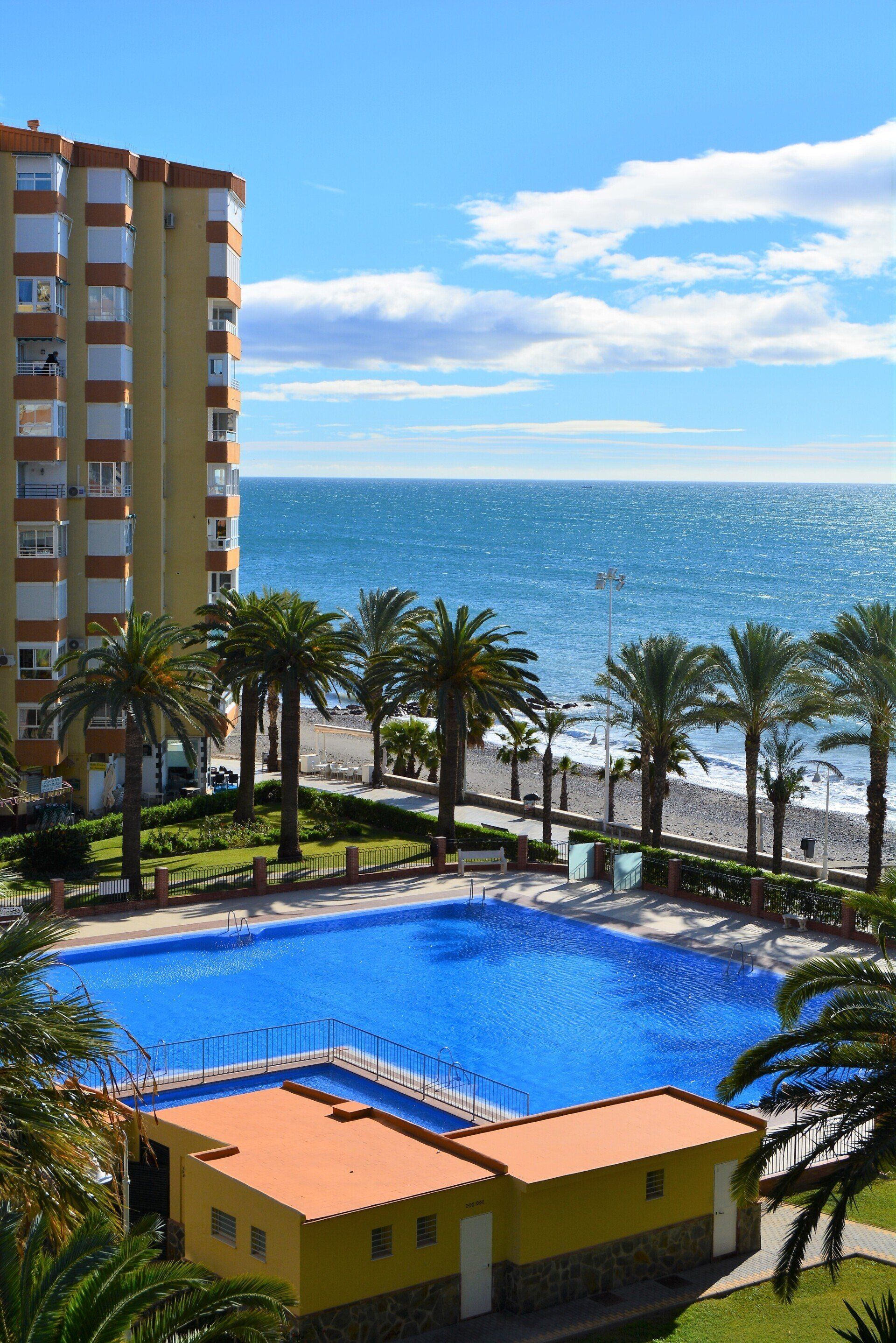 Blick über den Swimmingpool , die Palmenpromenade und den Strand auf das Meer