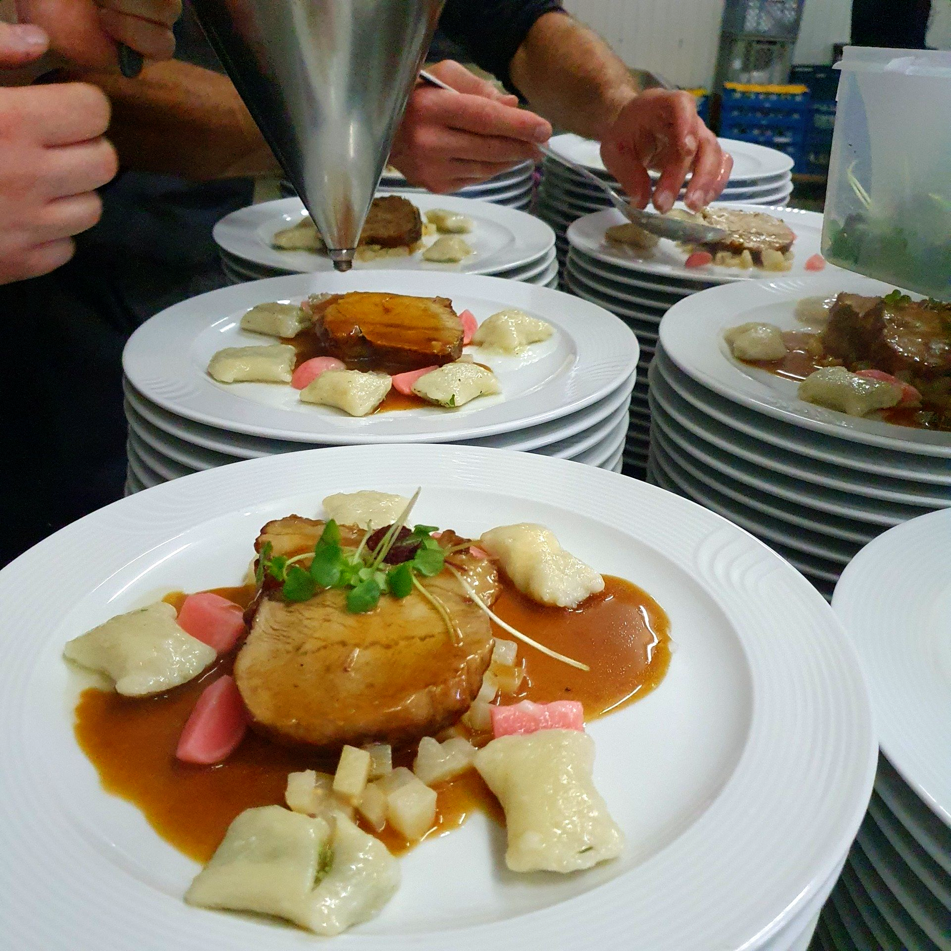 Hauptgericht mit Fleisch, Gnocchi und Sauce auf weißem Teller