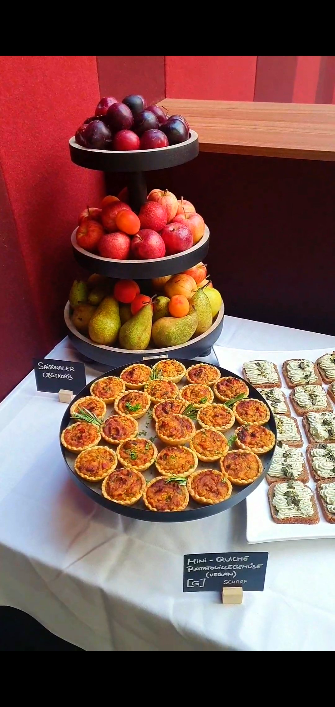 Buffet mit Obst, Mini-Quiche und belegten Broten