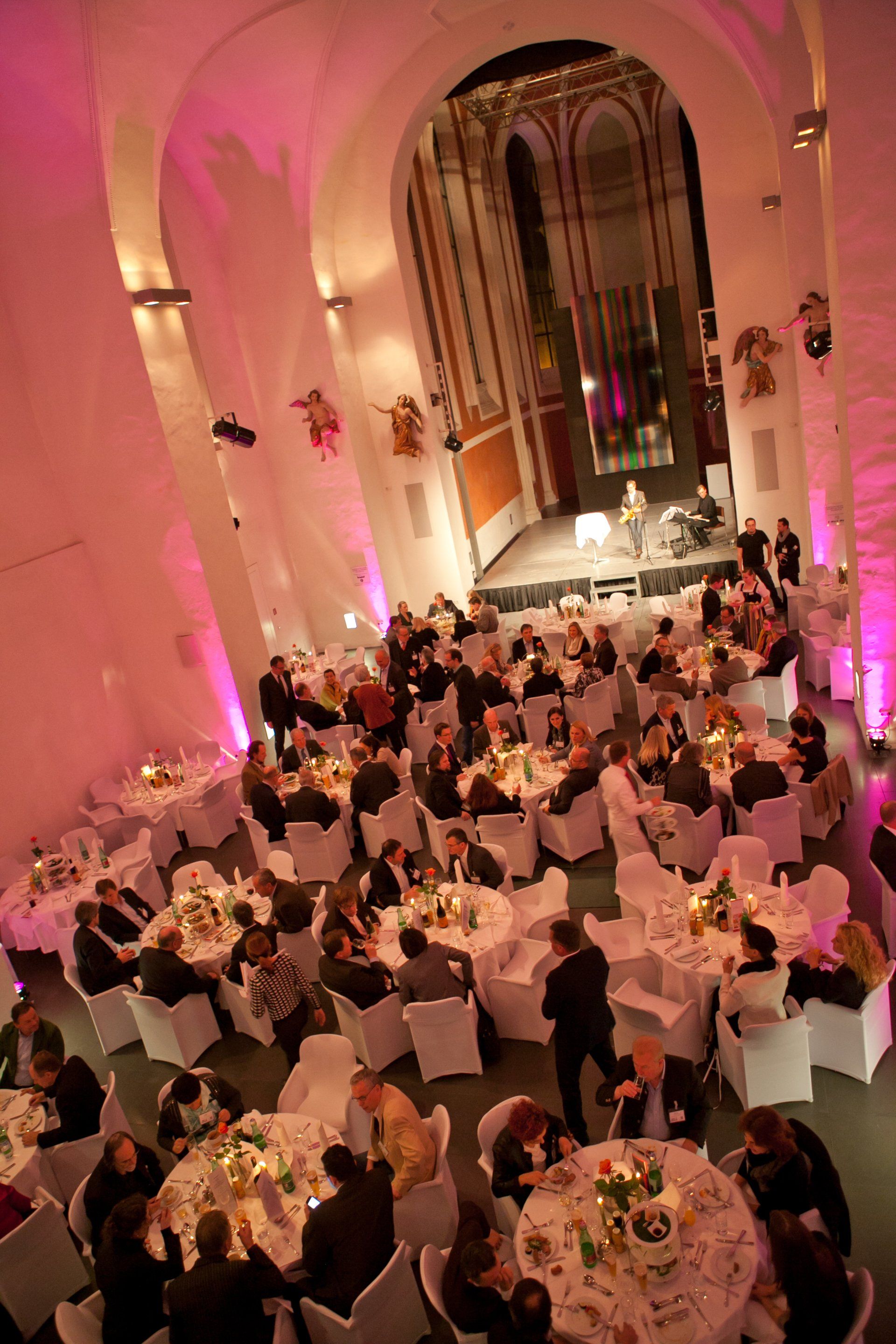 Gala-Dinner mit Gästen in festlich beleuchtetem Saal.