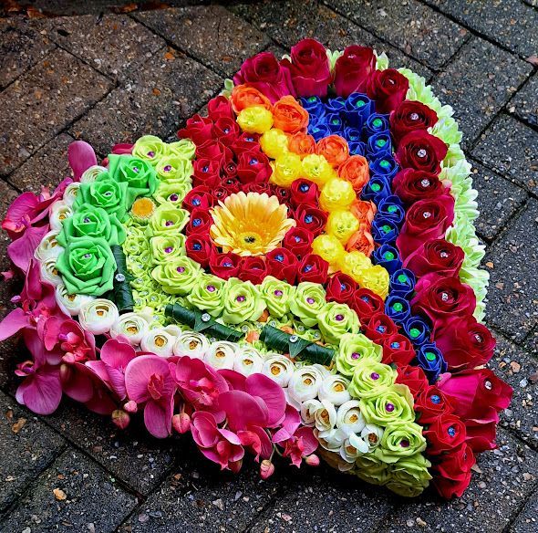 Custom Made Artificial Flower Funeral Tribute in a rainbow of colours and flowers in a heart shaped design