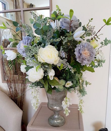 Large silk flower arrangement in a pewter urn in shades of grey, ivory and white with artificial foliage