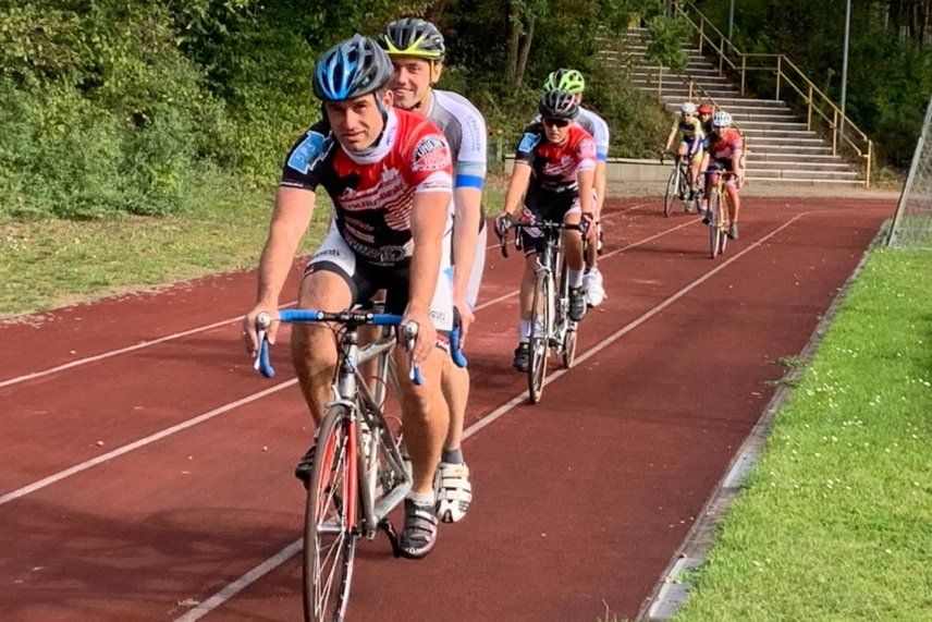 Jugendliche fahren zusammen auf der Radrennbahn Augsburg, teils mit Single-Bahnrad, teils mit Bahnradtandem