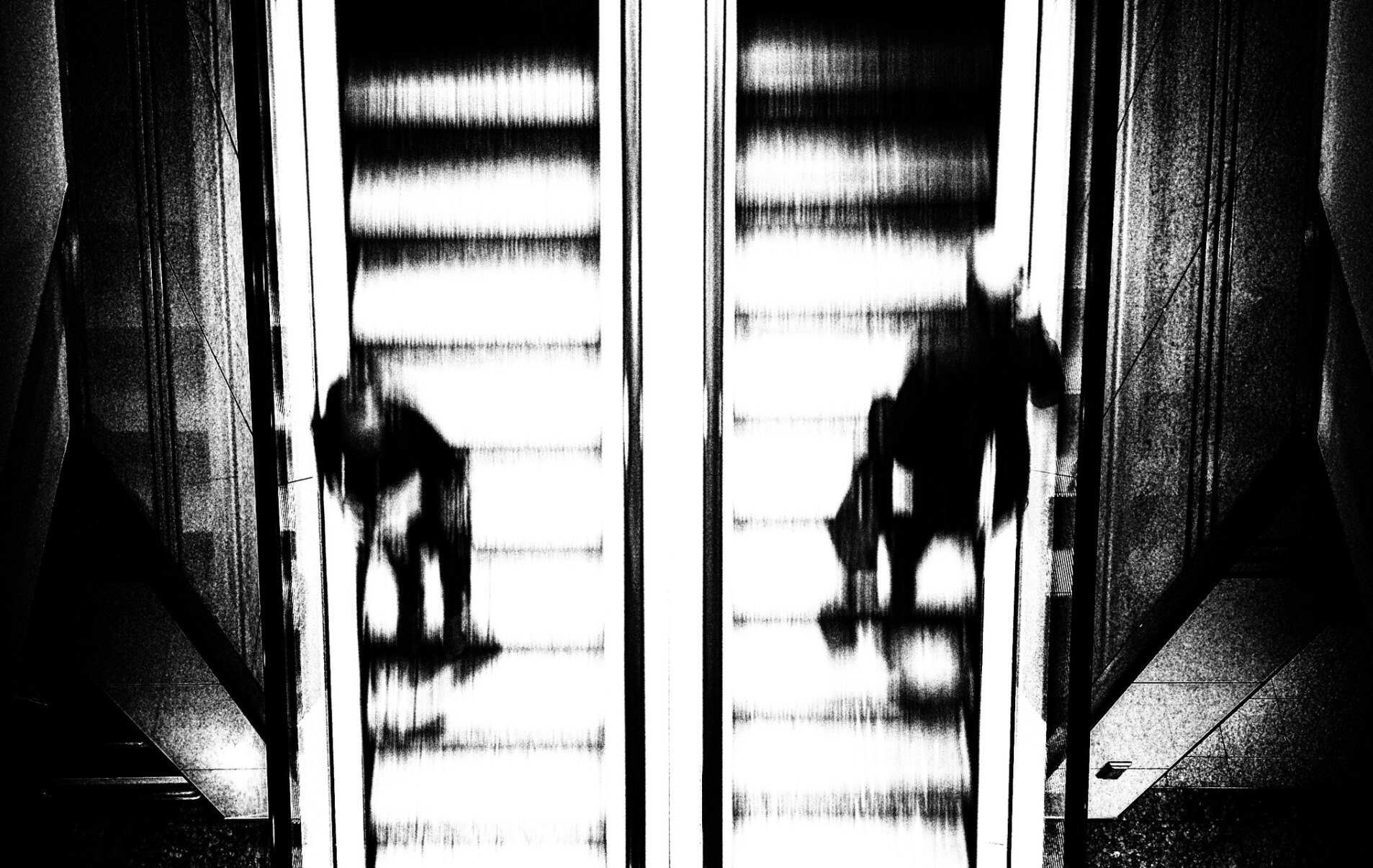 Abstrakte Street photography - Ein Mann und eine Frau fahren auf einer Rolltreppe aneinander vorbei