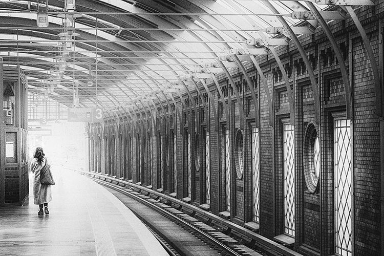 Schwarz weiß Fotografie einer Frau auf dem Bahnsteig Bahnhof Hackescher Markt in Berlin