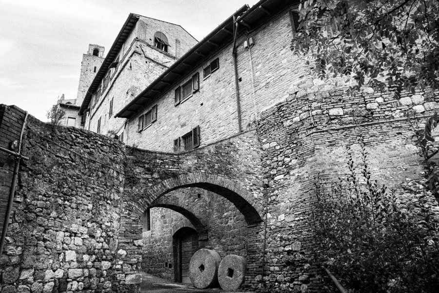 Schwarz weiß Fotografie alte steinerne Mühlenräder in der Altstadt von San Gimignano.