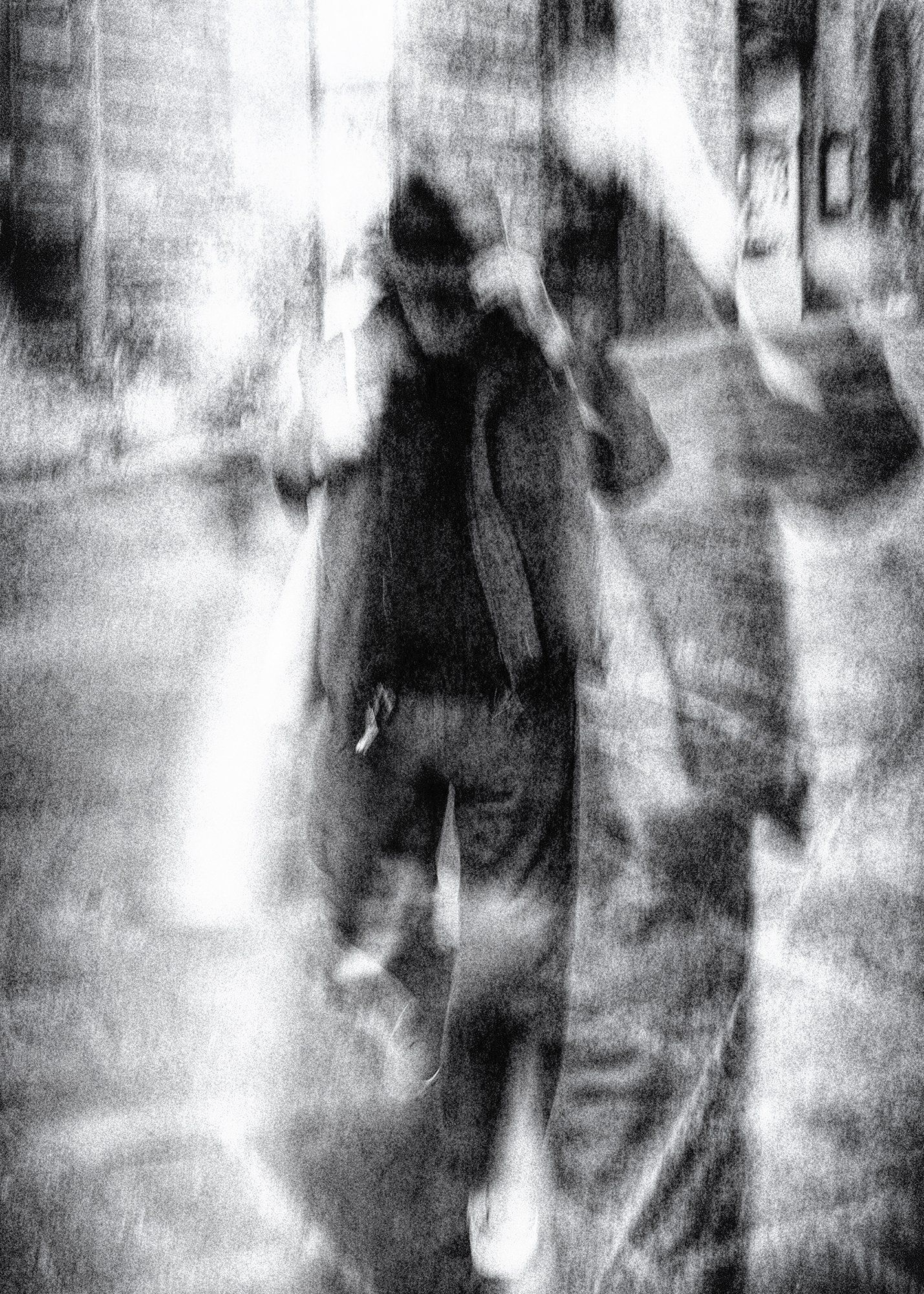 Ein Mann mit Hut geht eilig durch die Altstadt von Siena in der Toskana. Abstrakte Straßenfotografie aus Italien in schwarz weiß.