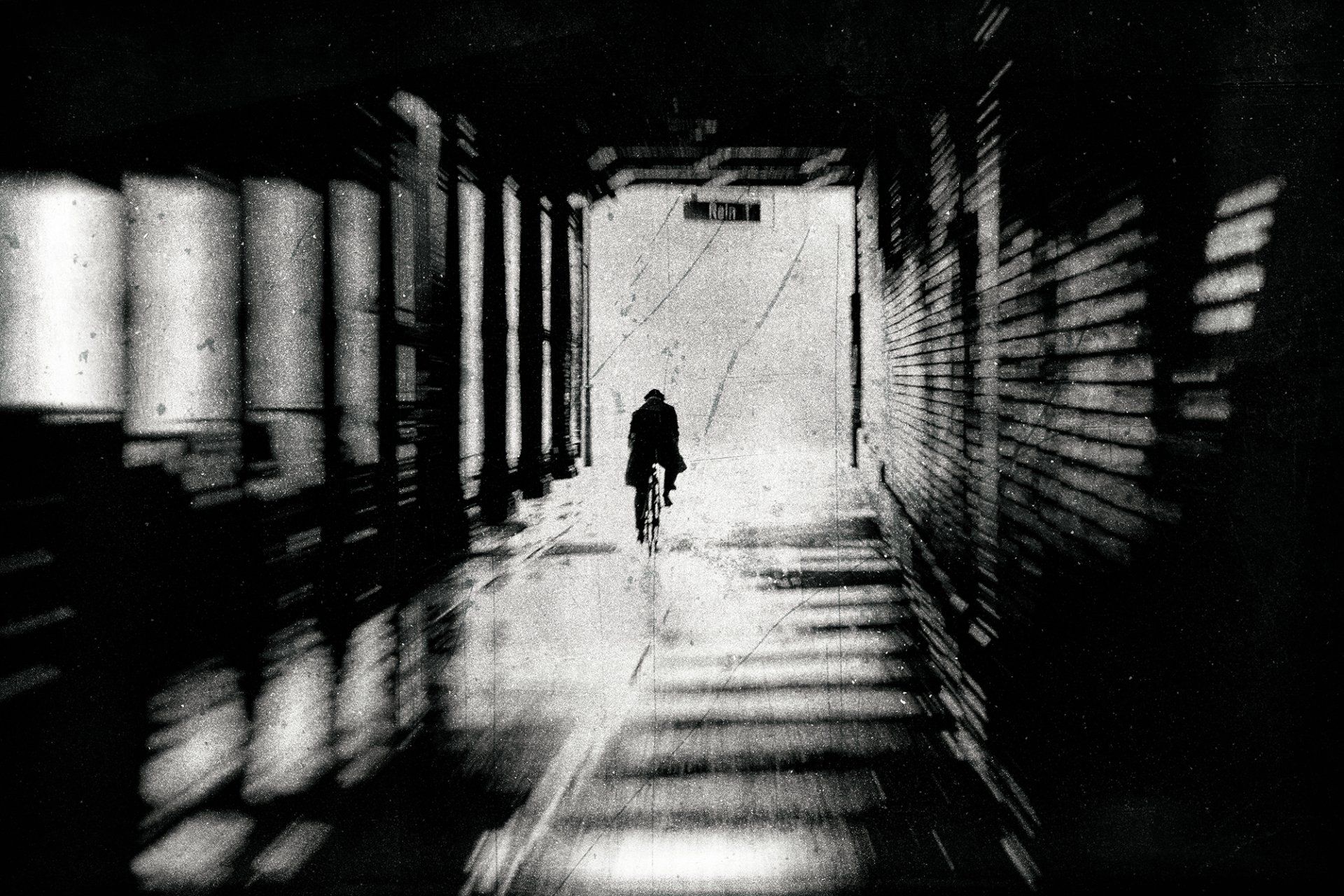 Ein Radfahrer fährt eilig durch den Gleimtunnel in Berlin Prenzlauer Berg. Abstrakte Straßenfotografie aus Berlin in schwarz weiß.